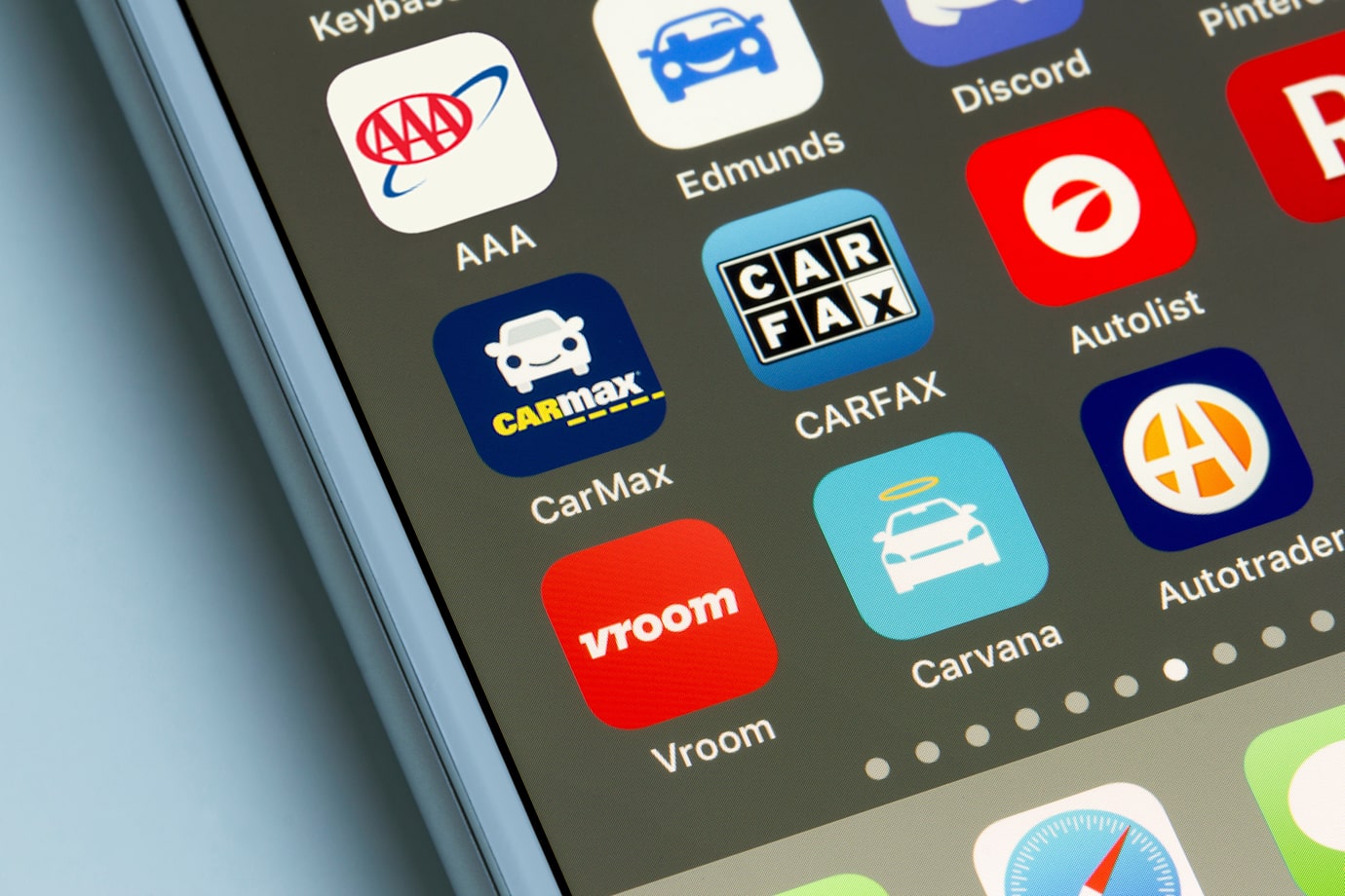 A smartphone with online car buying apps on the screen.