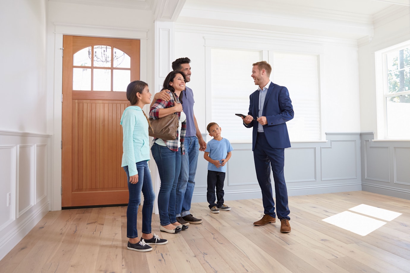A family looks at an open house with their real estate agent.
