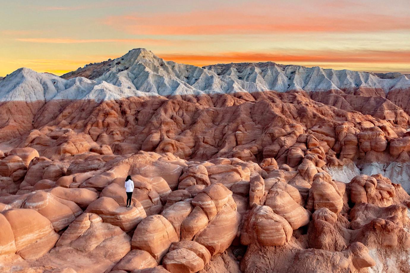A woman stands on the badlands in Grand Staircase Escalante National Monument.