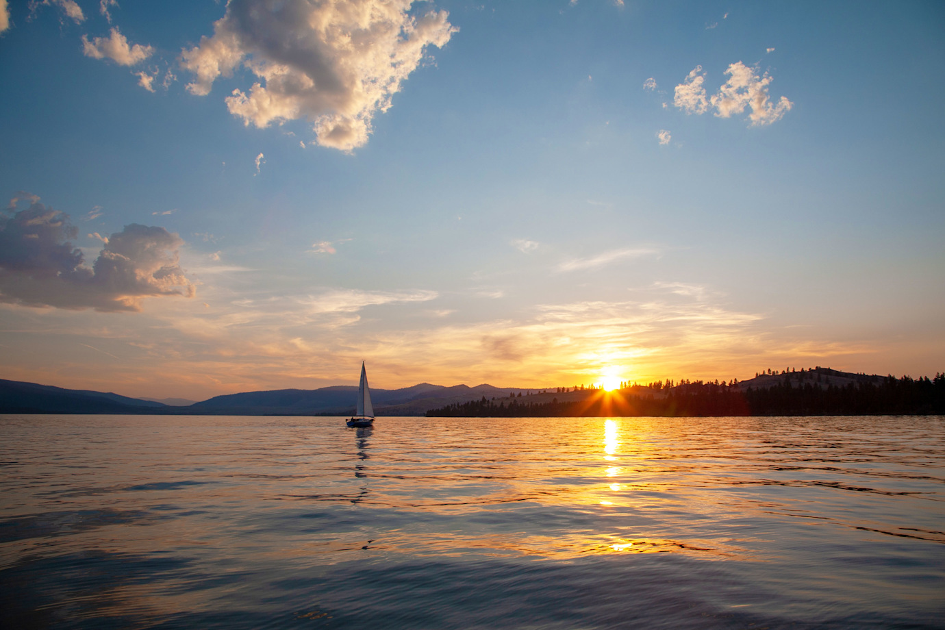 A boat sails at sunrise near Wildhorse Island on Flathead Lake near Kalispell, Montana.