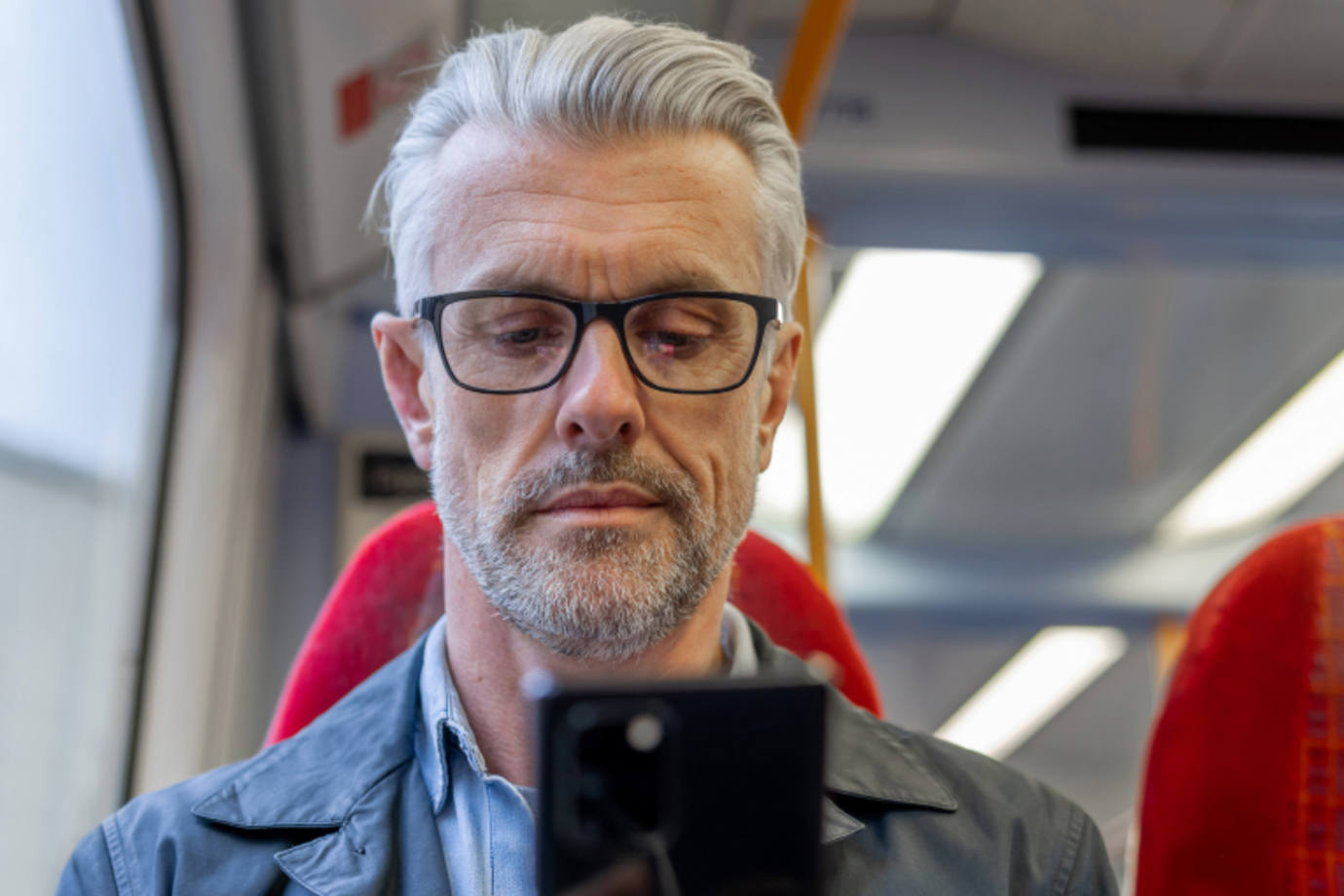 man looks at his phone after being notified of a data breach