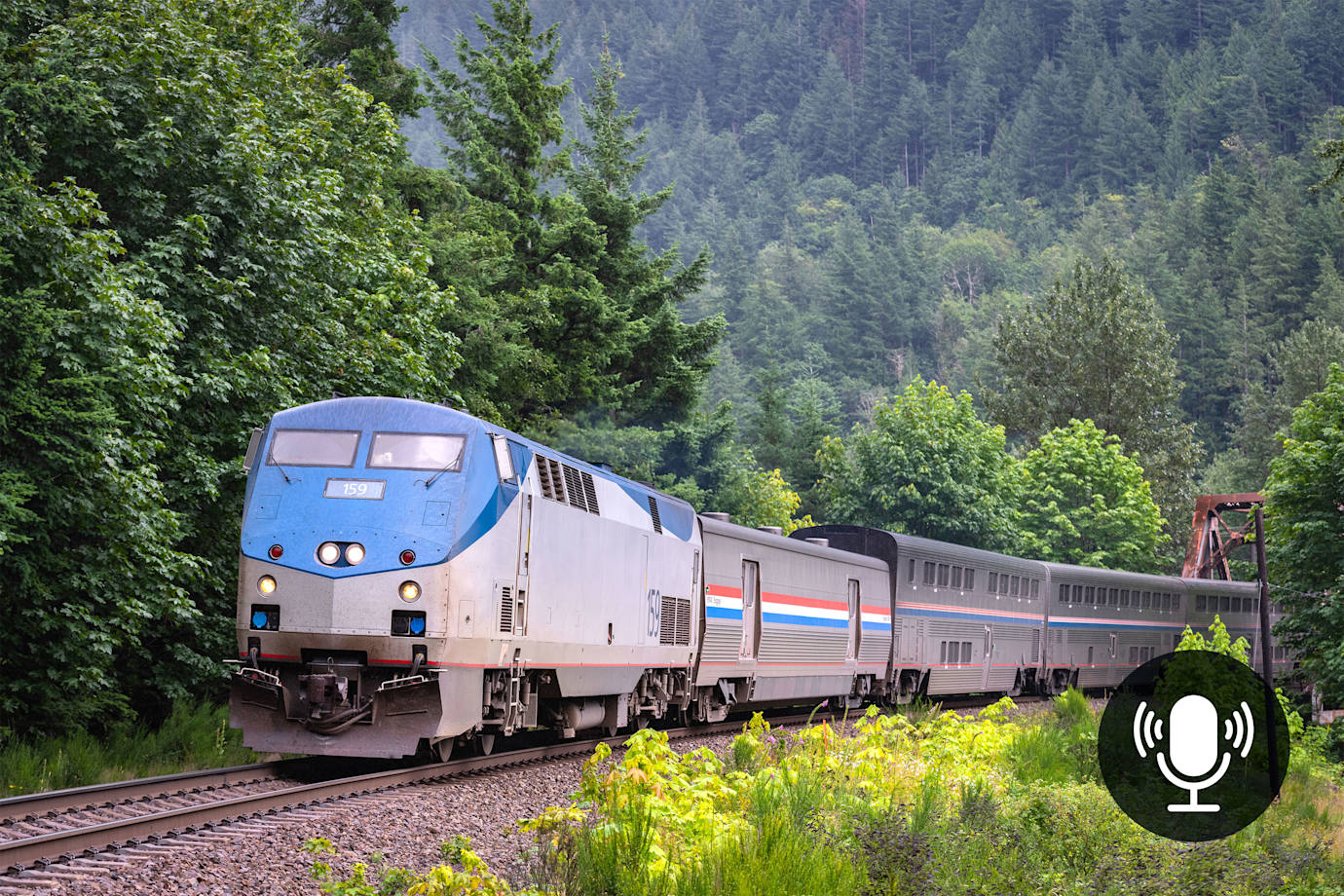 Amtrak's Empire Builder train on a forested railroad track.