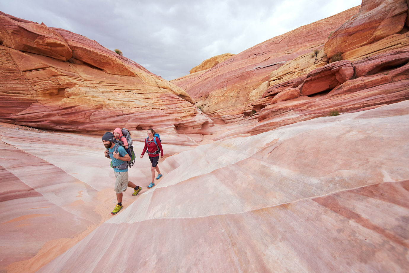 A family hikes through the vibrant rocks at Valley of Fire State Park, Nevada.