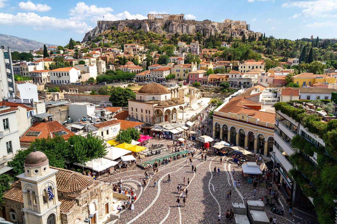 Elevated view of Monastiraki Square in Athens, Greece with the Acropolis overlooking the city in the background.