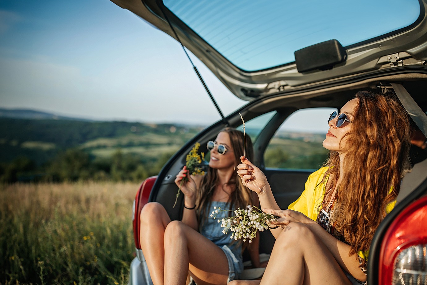 group hiking by a Hertz rental car booked through AAA