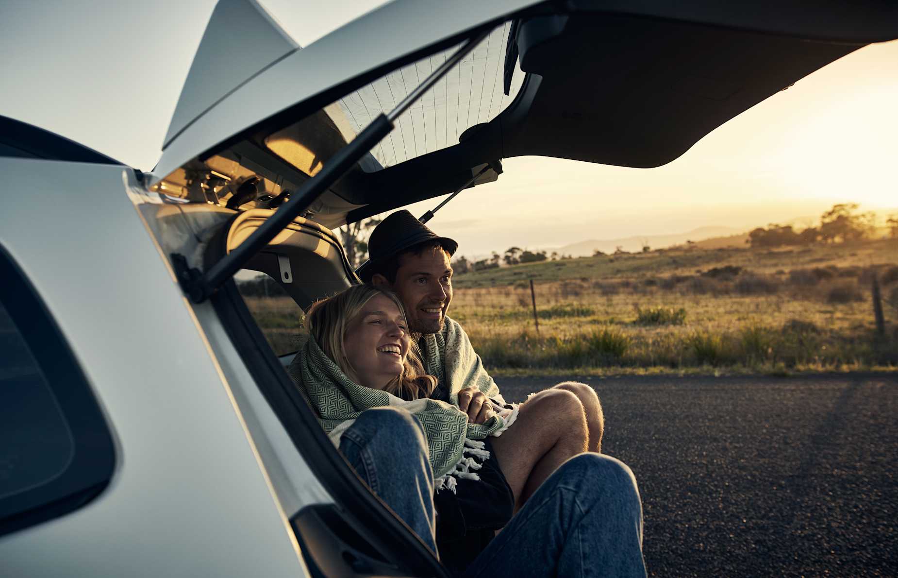 AAA Plus Members sit in the back of the hatchback to watch the sunset