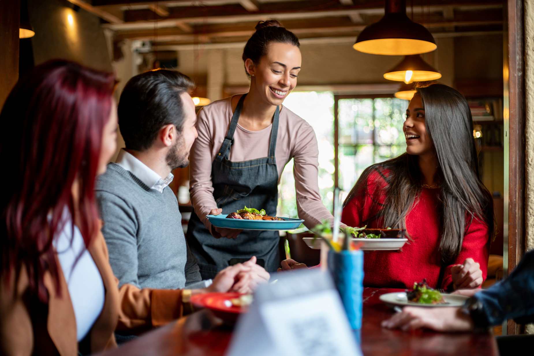 A waitress serves a group of AAA Members lunch