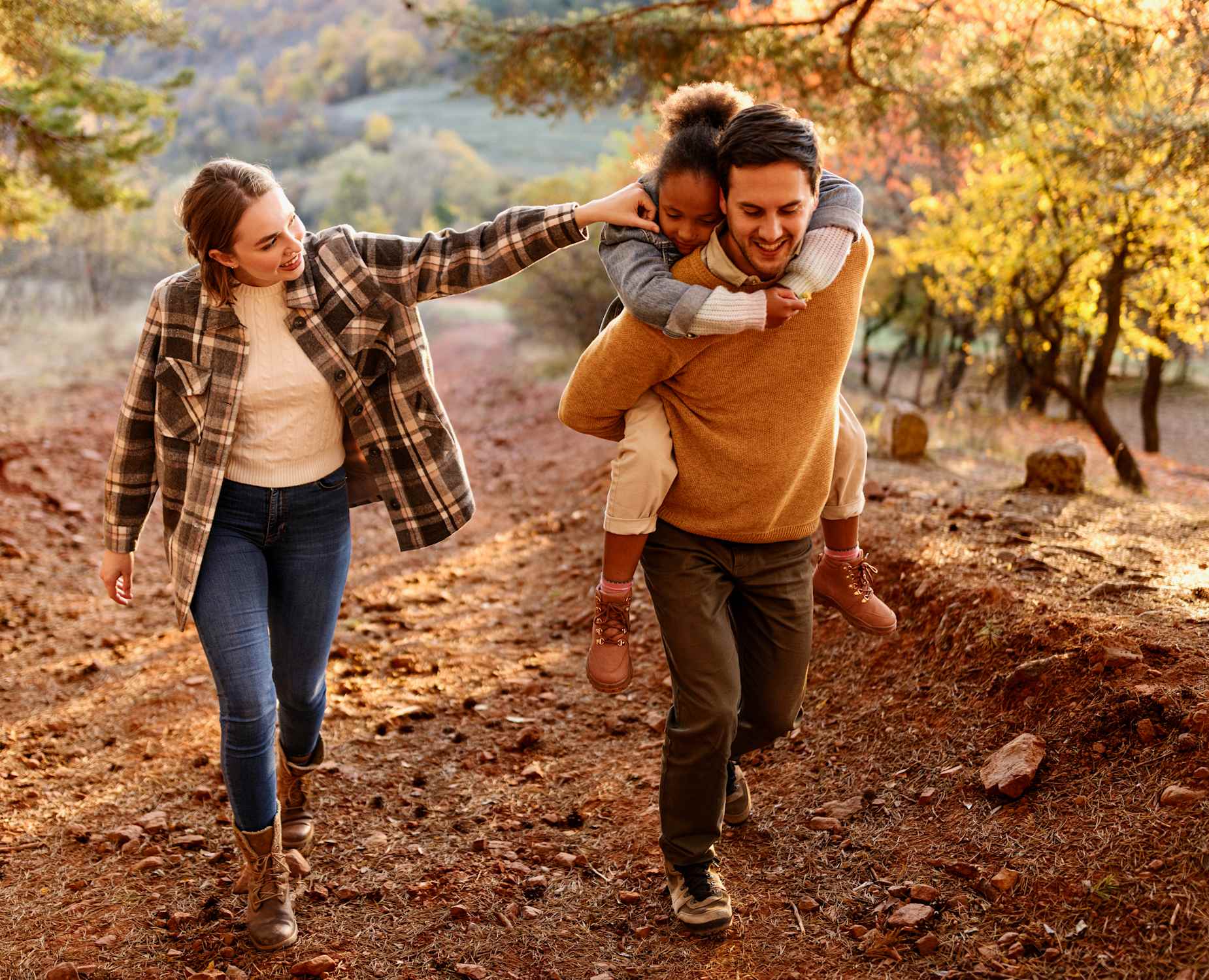 man and woman hiking with child in autumn setting