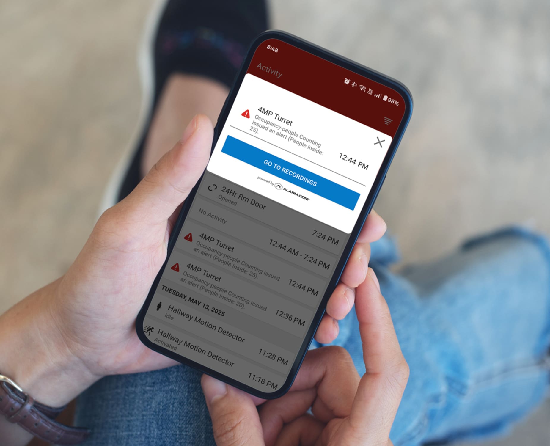 someone looks at an alert on their phone, part of intrusion detection from AAA Smart Business Security