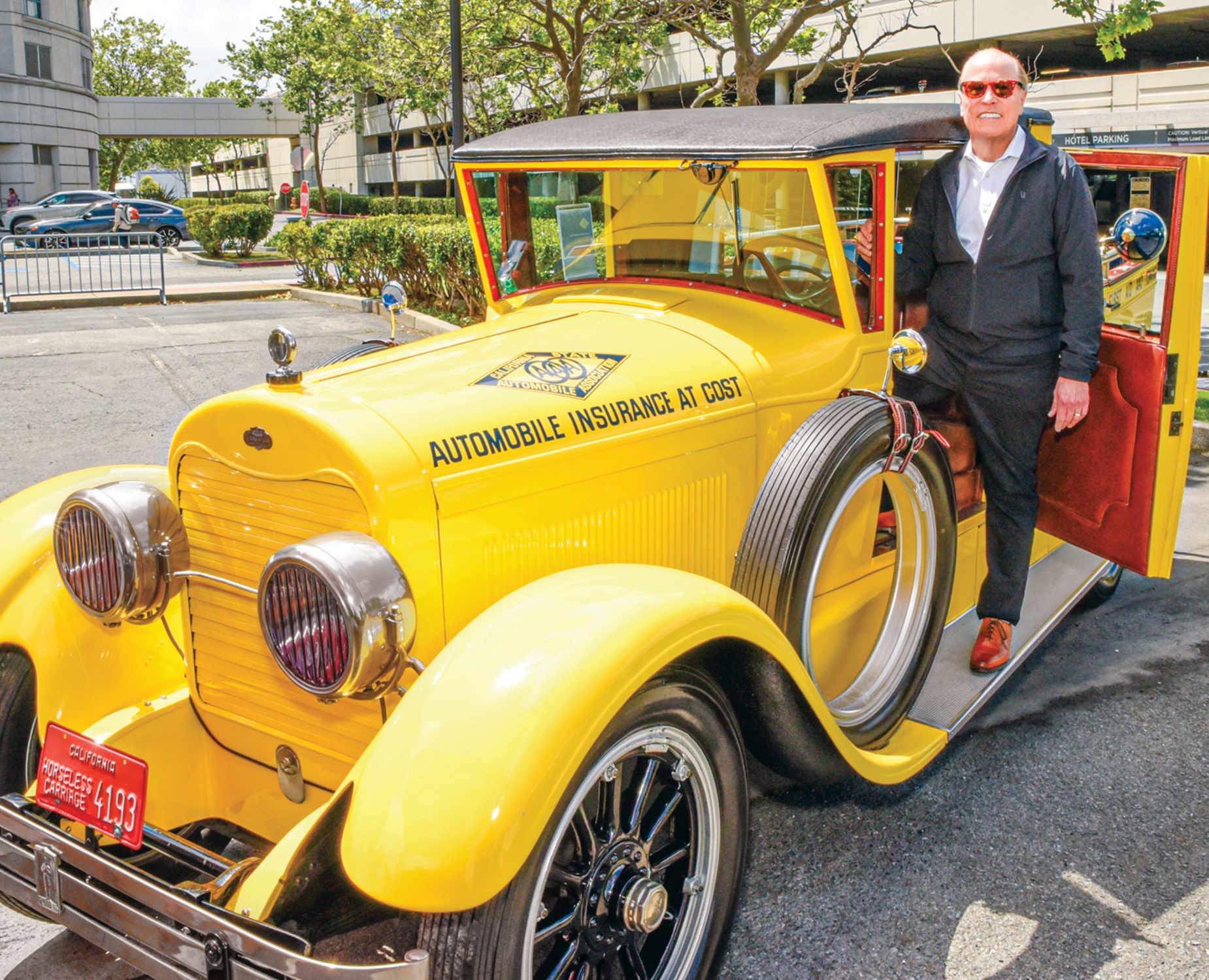 AAA Mountain West Group CEO Marshall Doney stands with a classic car
