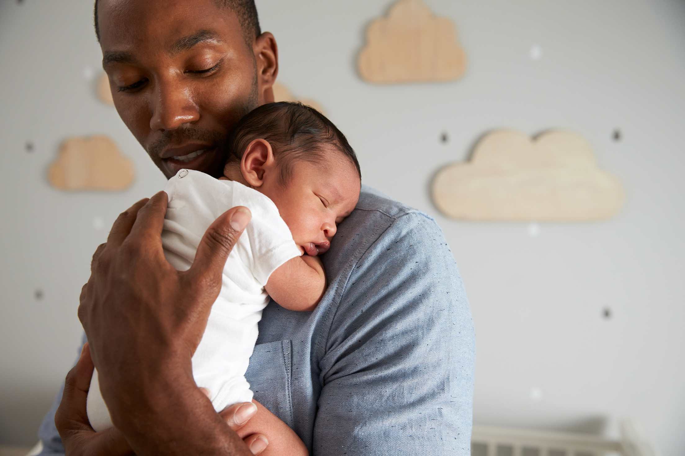 A dad holds his newborn in the nursery.