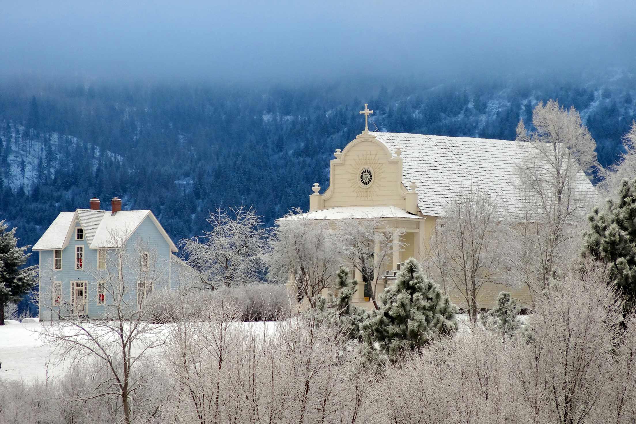 photo of an old house and church covered in snow at Old Mission State Park