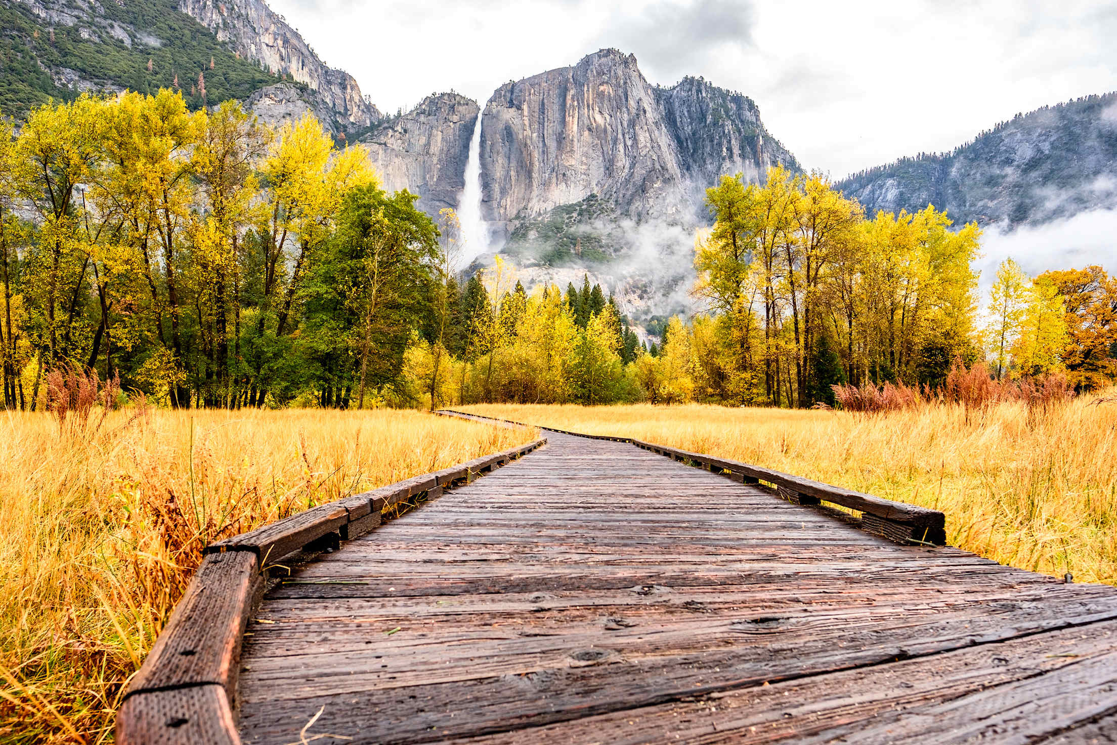 Boardwalk trail in Yosemite Valley in fall with full waterfall in the background, picture