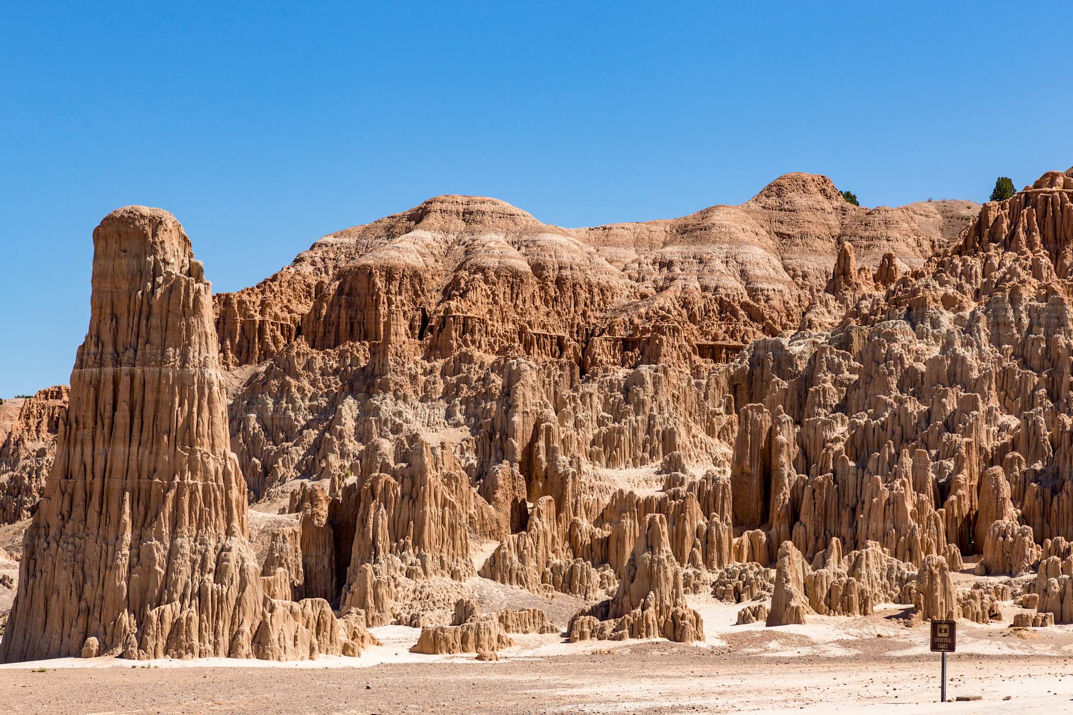 colorful rock formations rise up under blue skies at Cathedral Gorge State Park in Nevada, picture
