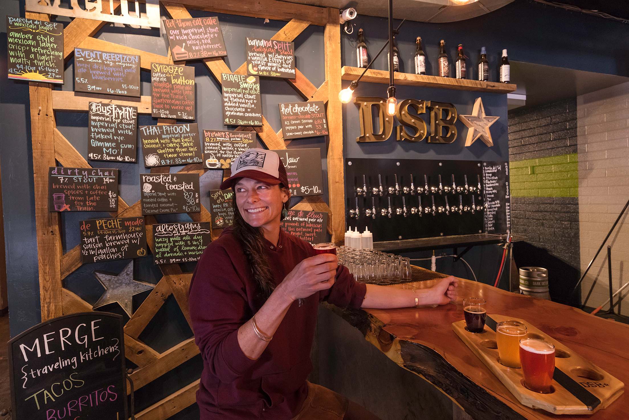 a woman pours beer at Dark Sky Brewing, picture