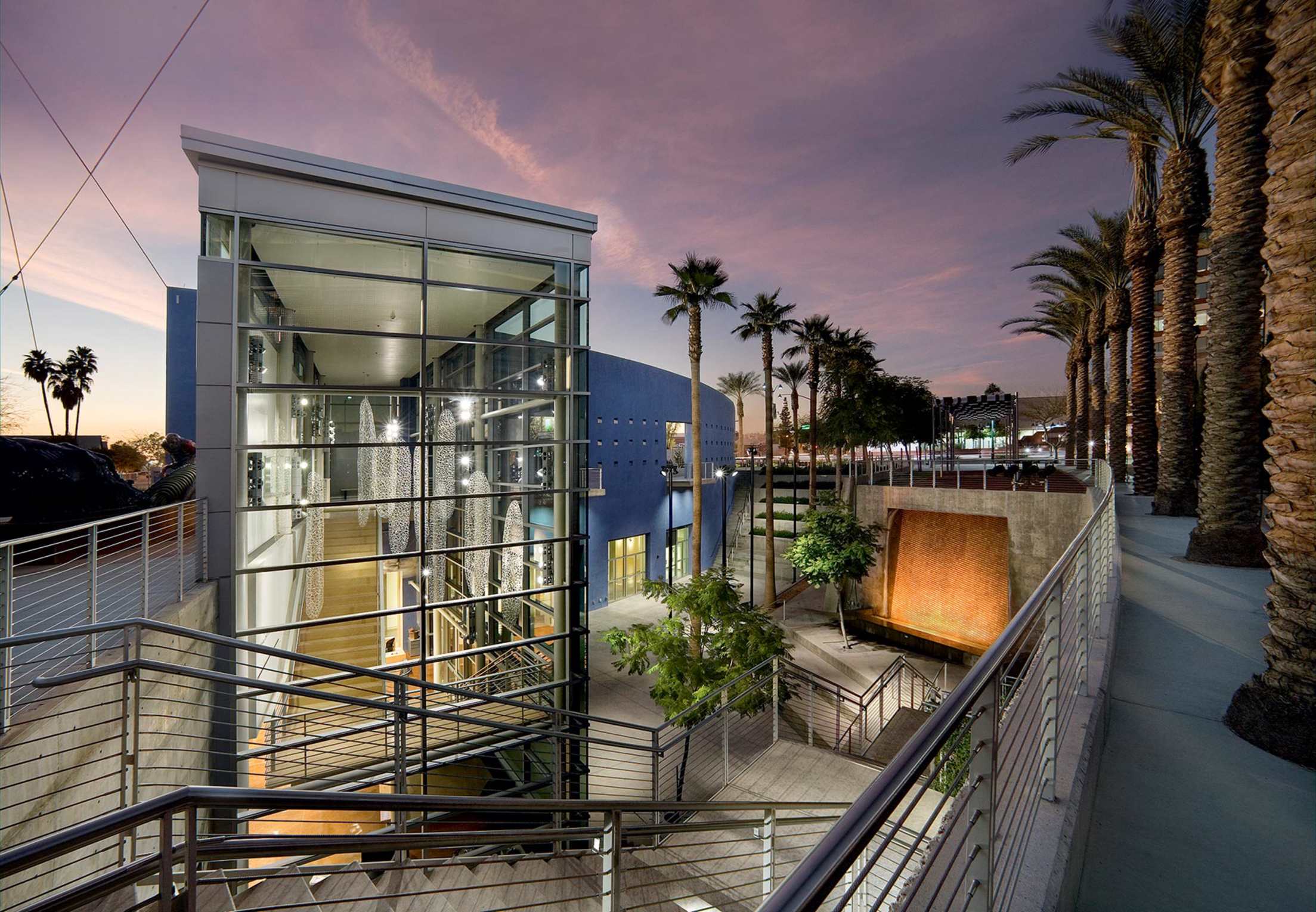 entrance to glass-walled, post-modern Mesa Contemporary Arts Museum at dusk, lined by date palms in Mesa, Arizona, picture