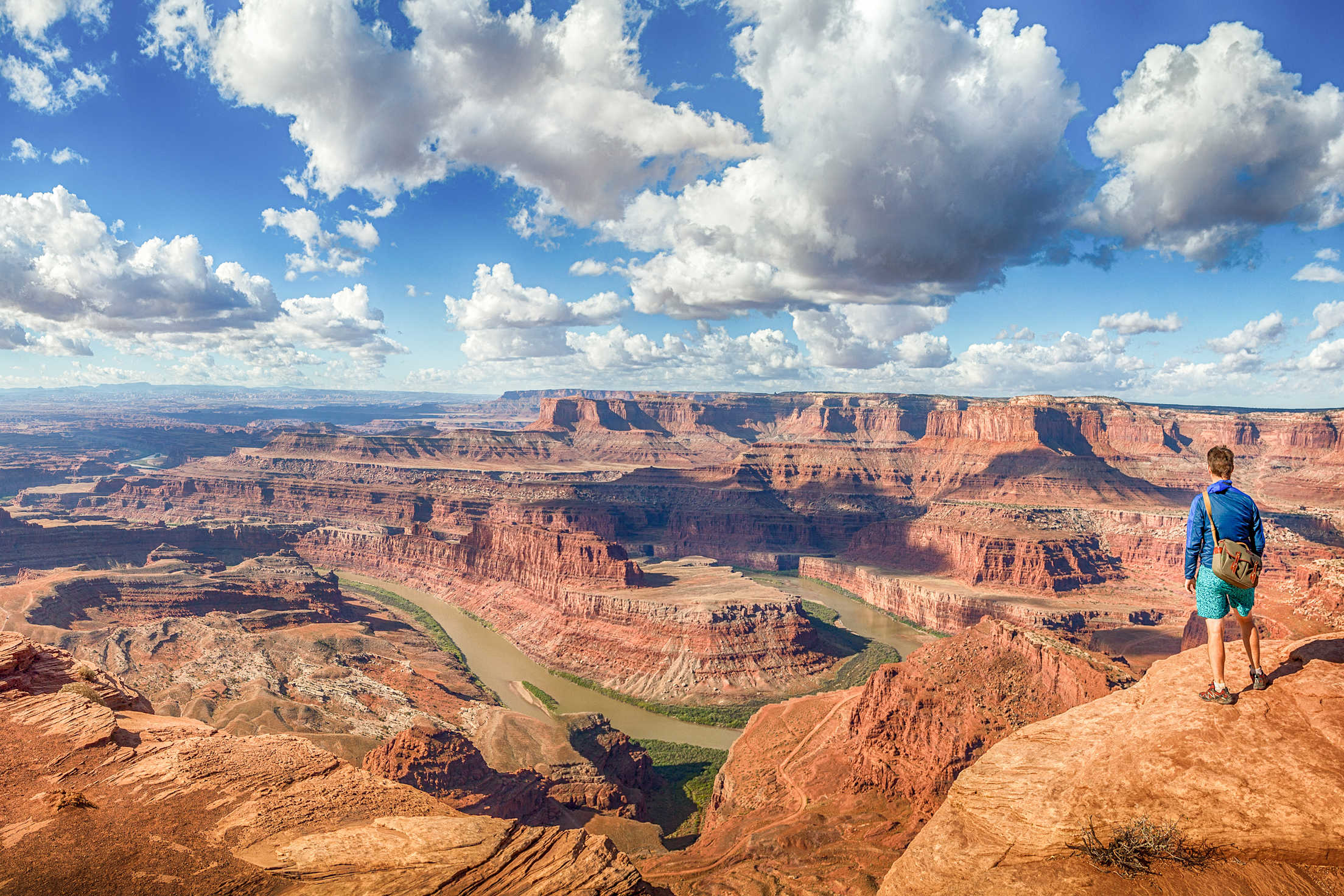 A man stands overlooking the Grand Canyon.