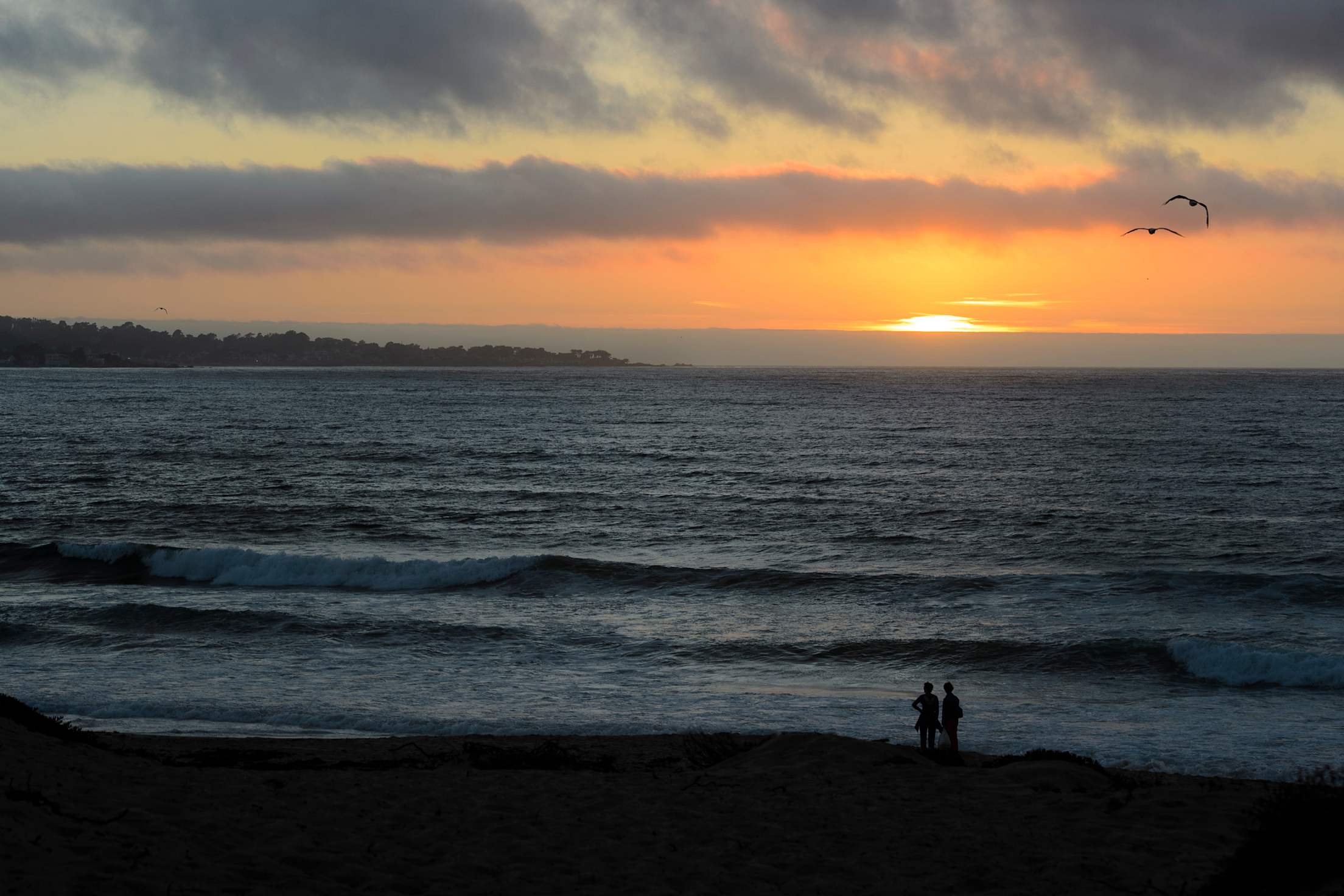the sun sets behind the cool waters of Monterey Bay, image