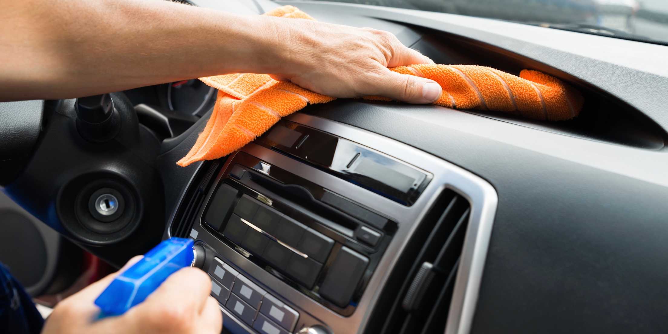 picture of male hands wiping down a dashboard