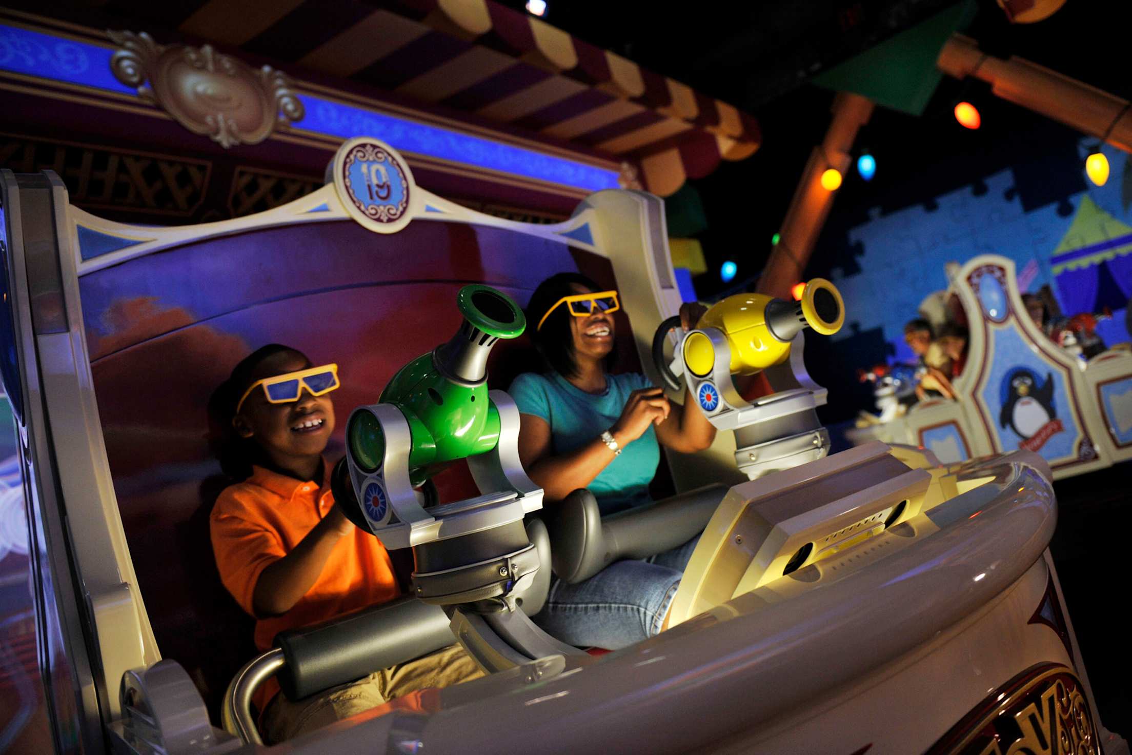 Mother and son play virtual carnival games at Toy Story Midway Mania! in Disneyland's California Adventures, image