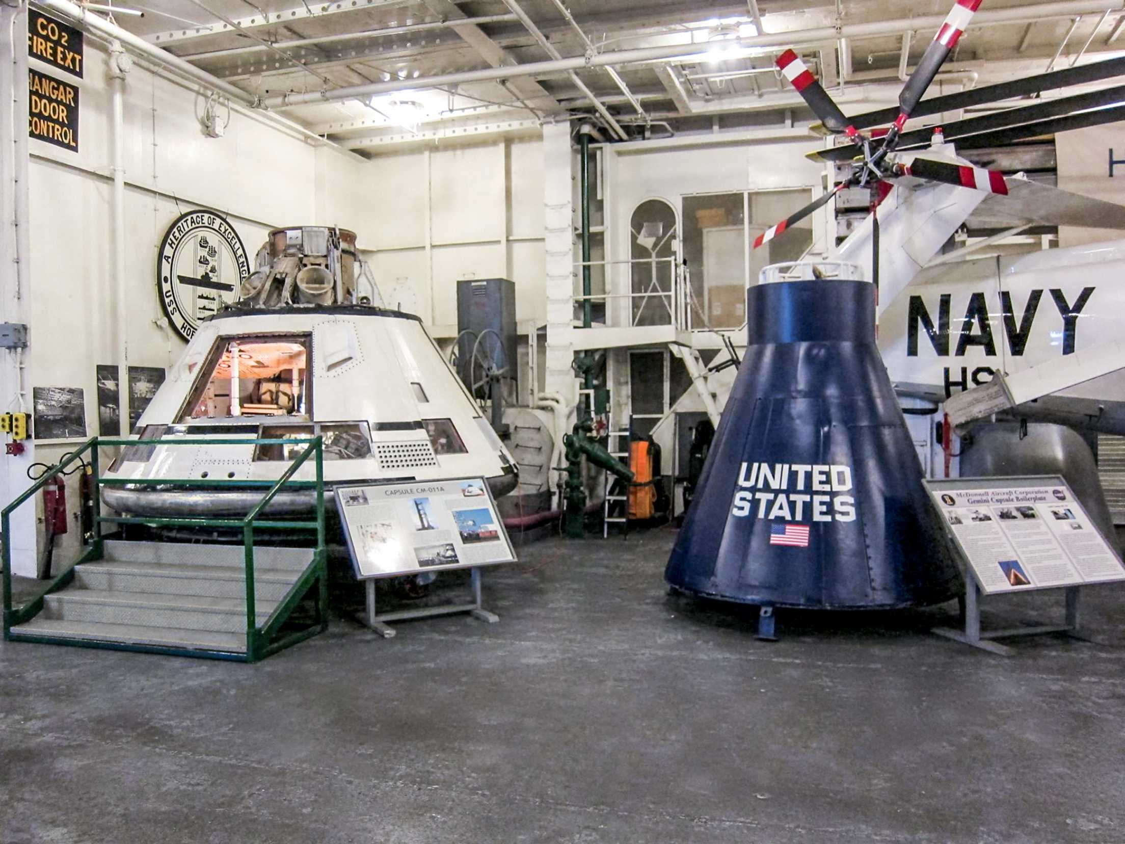 Apollo mission test capsule and a re-creation of lunar landing module on display at the USS Hornet's Hangar Bay 2 in Alameda, California