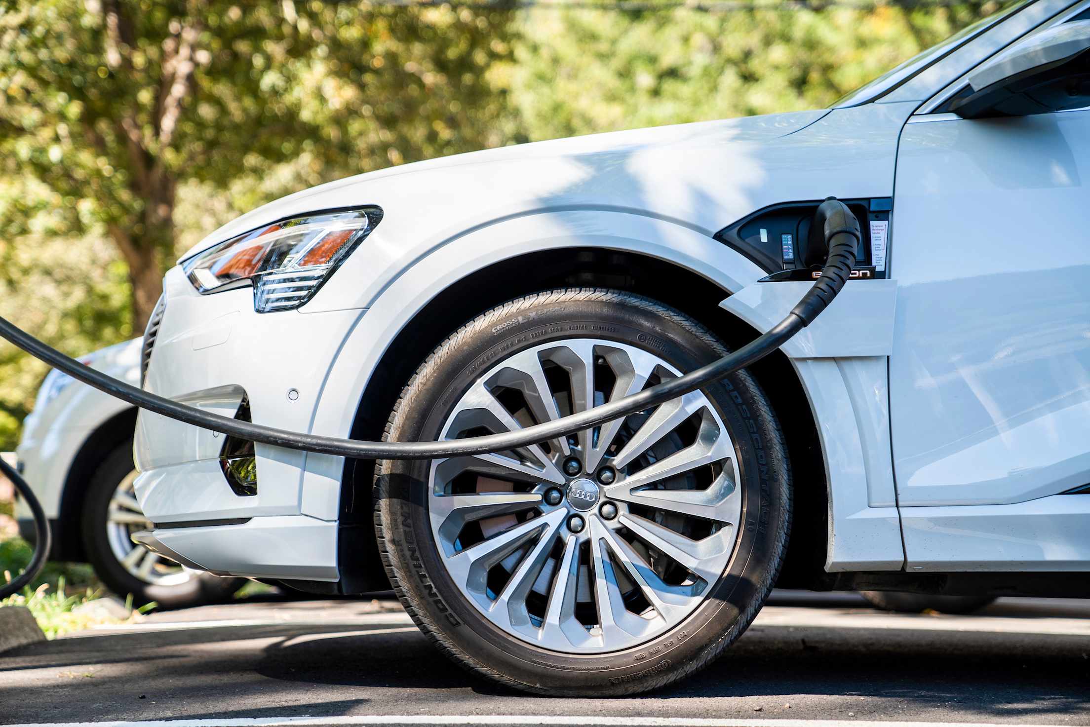 Audi E-Tron SUV plugged into a charging station.