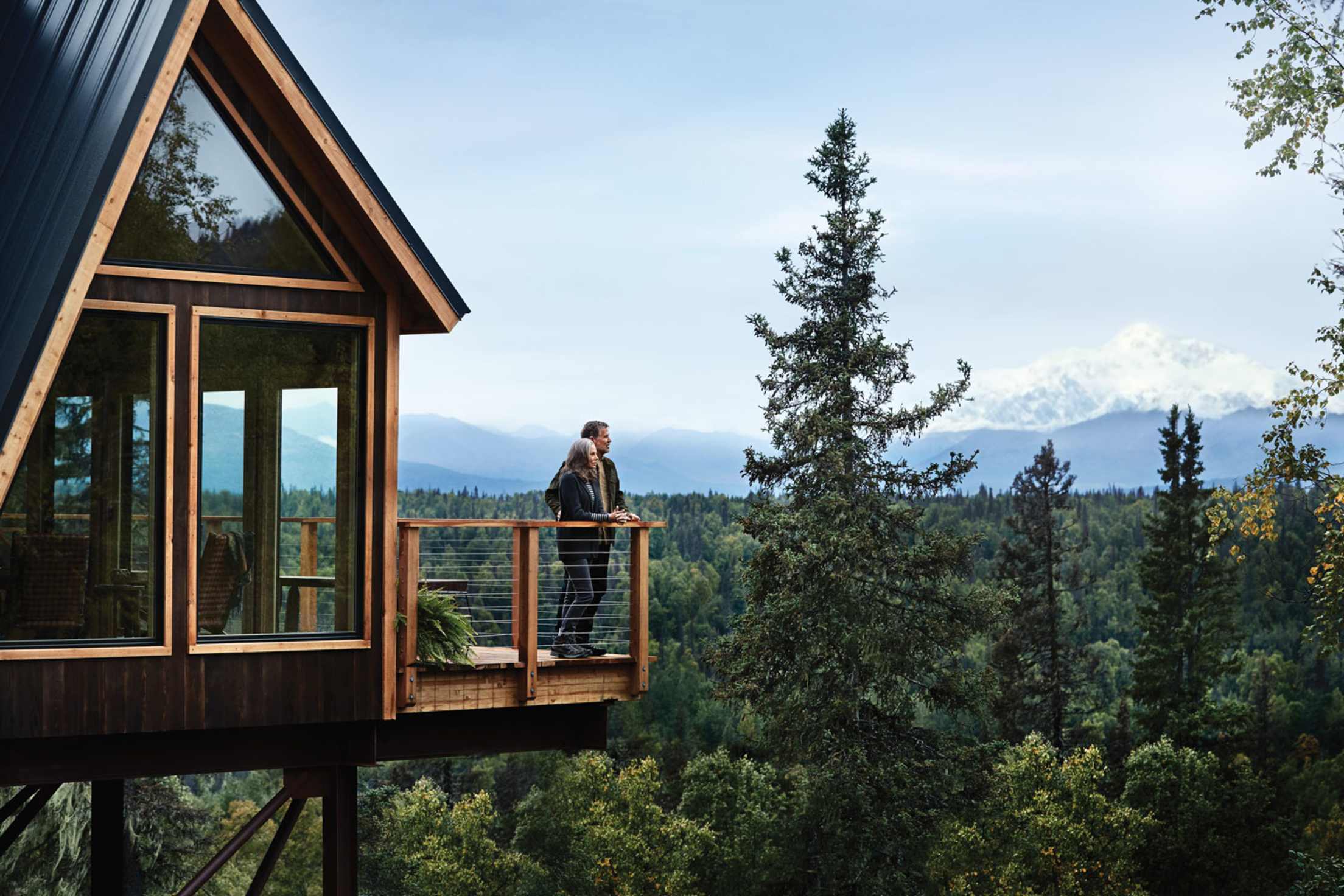 couple enjoy the view from a giant treehouse near Denali on a Princess Alaska cruisetour