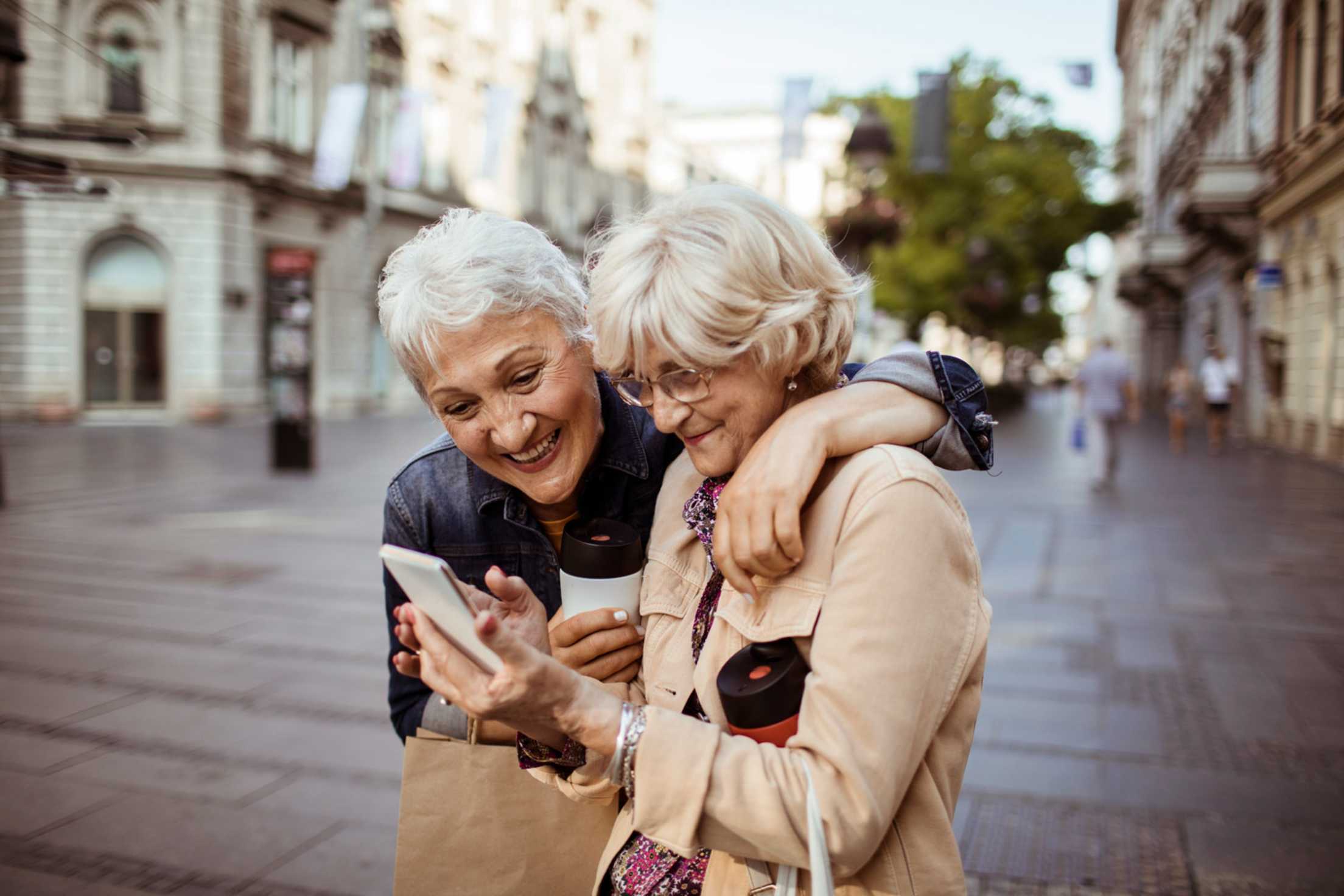 two women with reusable water bottles engaging in sustainable travel practices