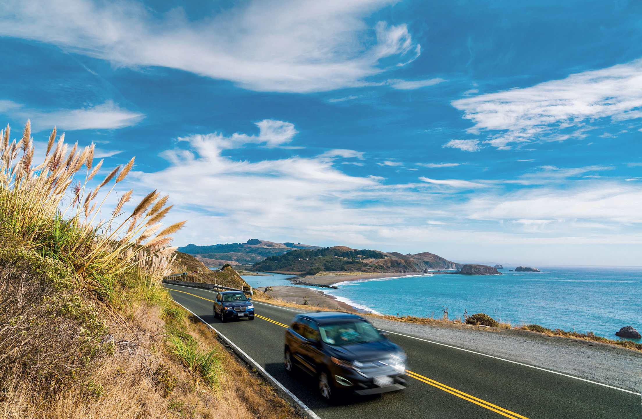 two cars heading north of on coastal California highway
