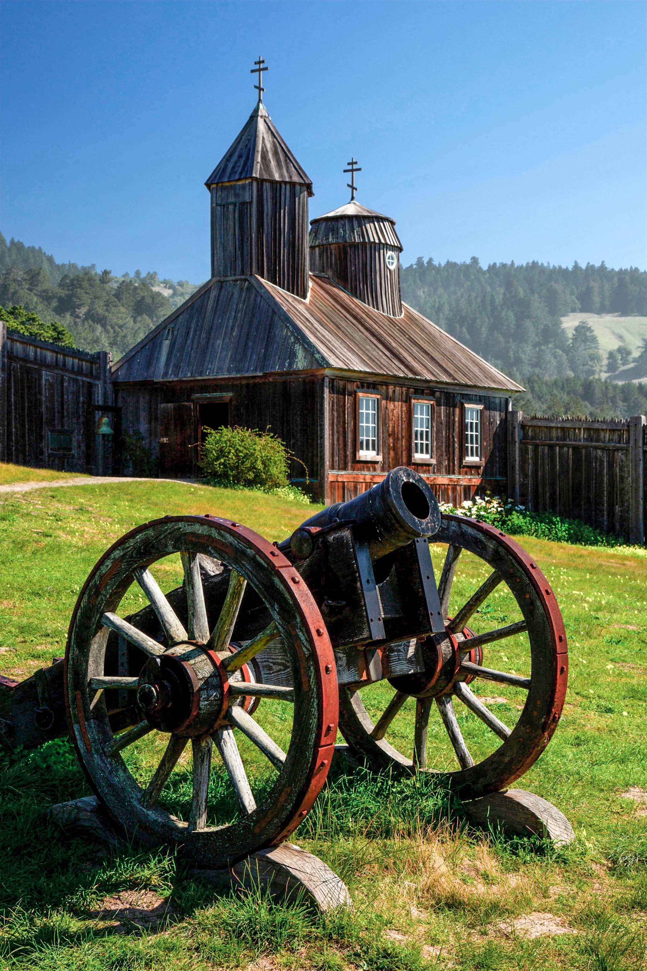 a wooden cannon on the green hillside outside Fort State Ross Historic Park
