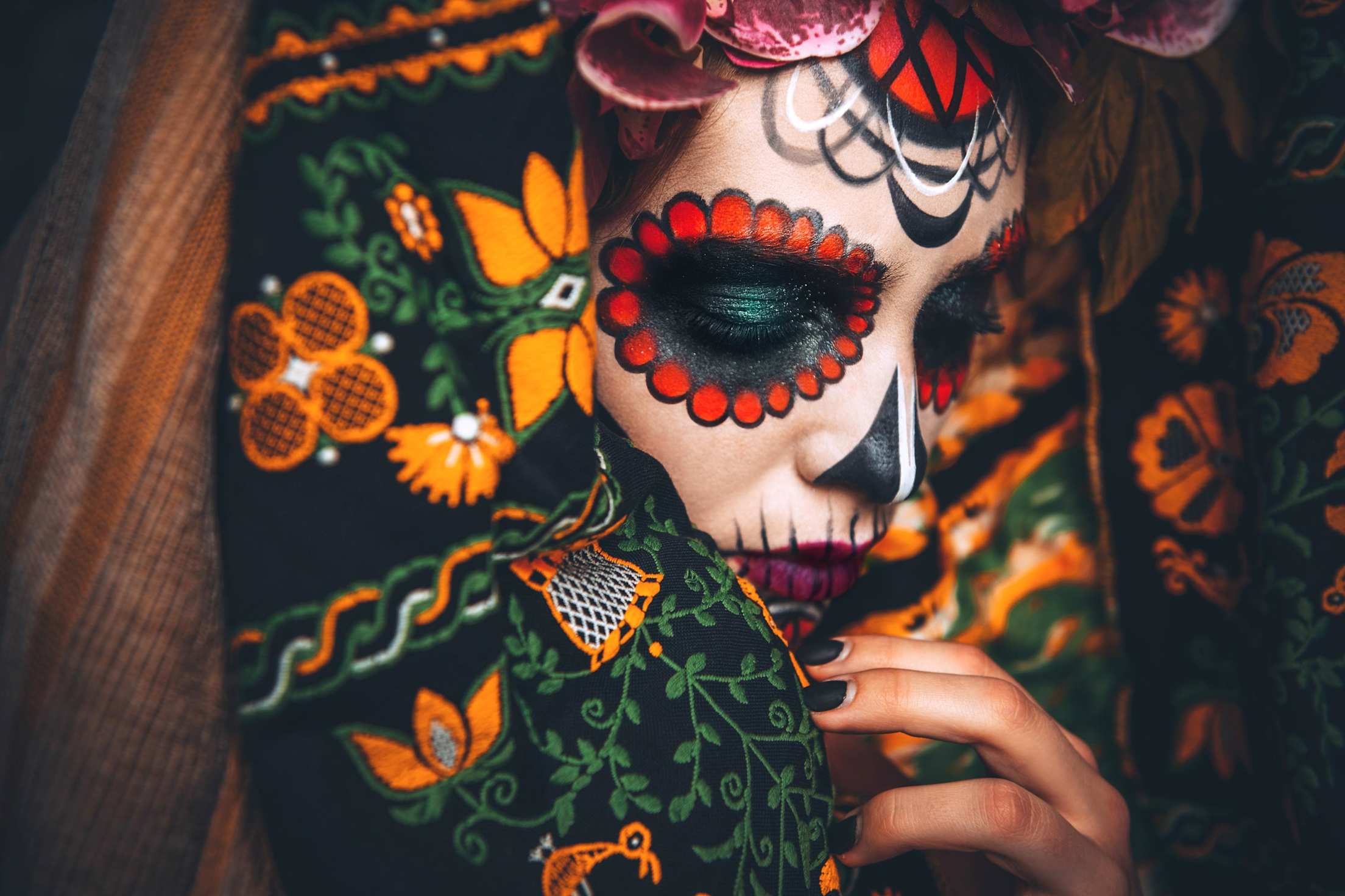 A young woman in a Dia de los Muertos makeup and face paint.