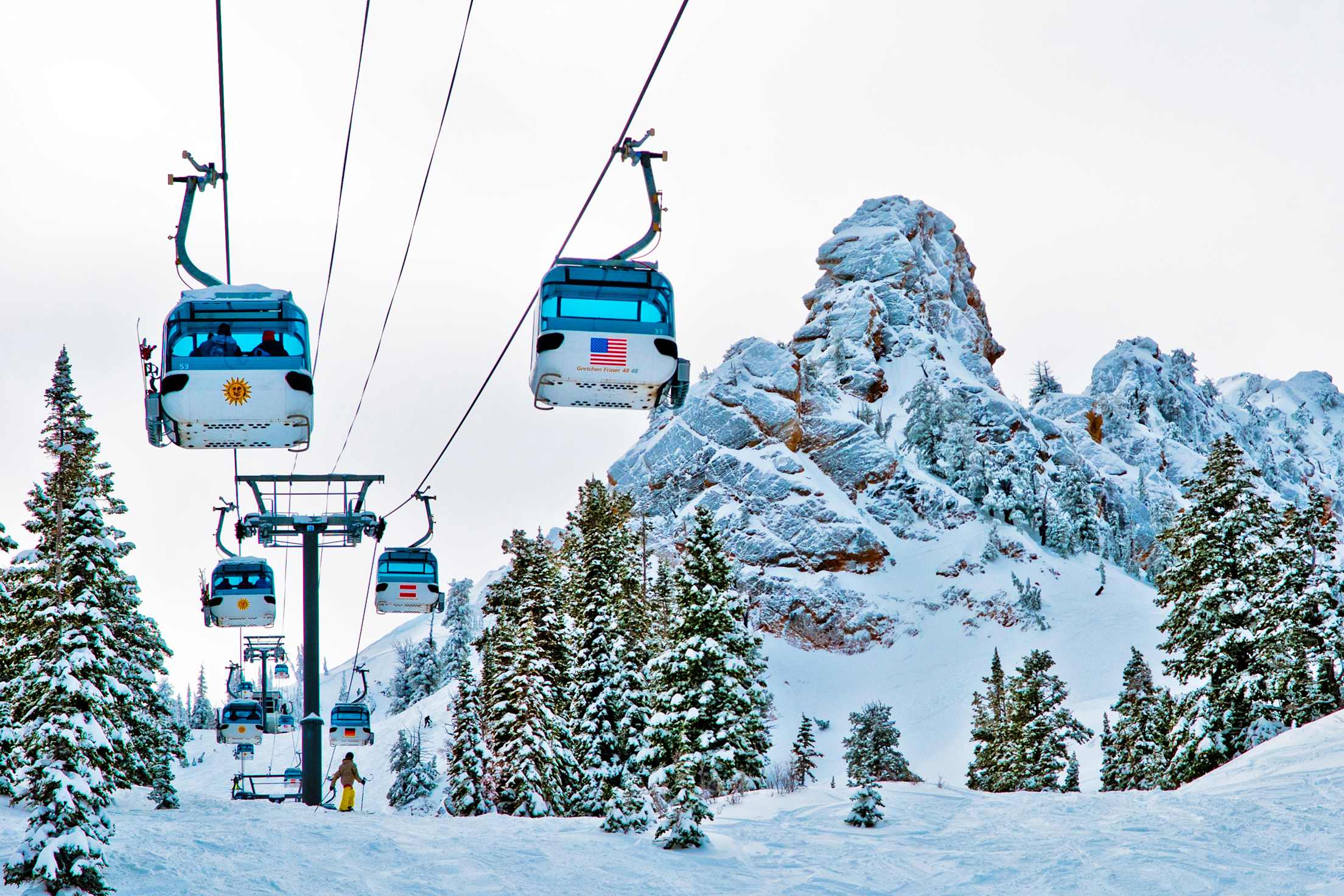 People ski beneath the Needles Gondola at Utah's Snowbasin Resort.