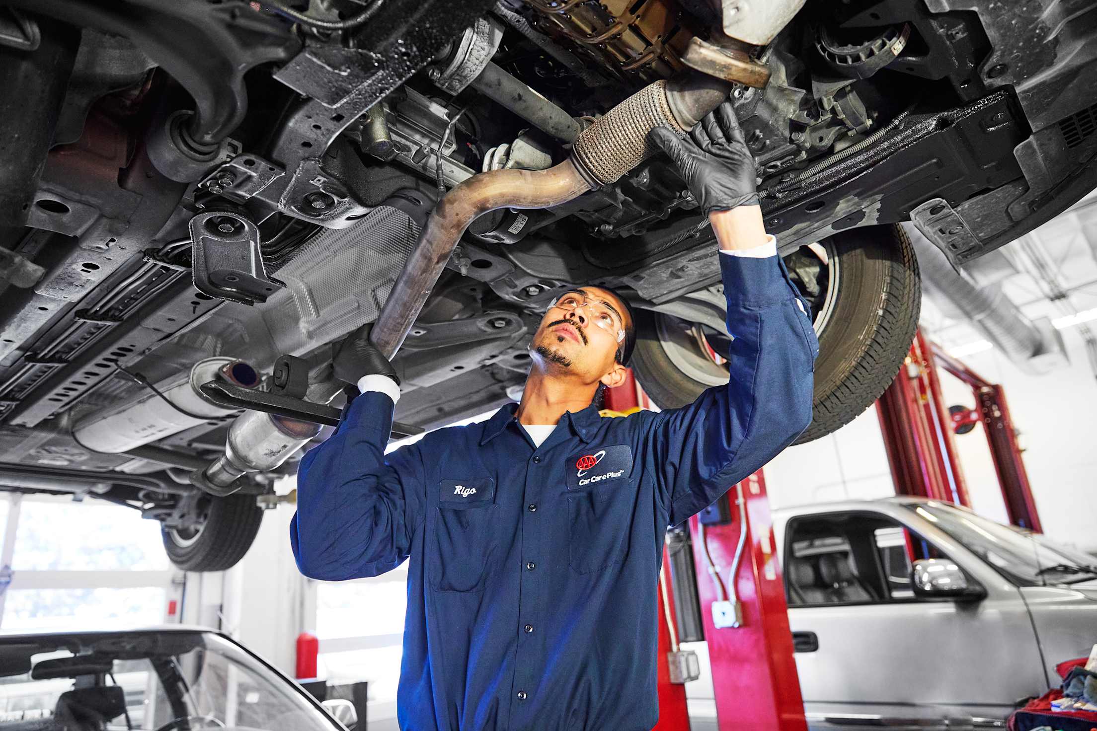 A AAA-approved auto mechanic works on a catalytic converter.