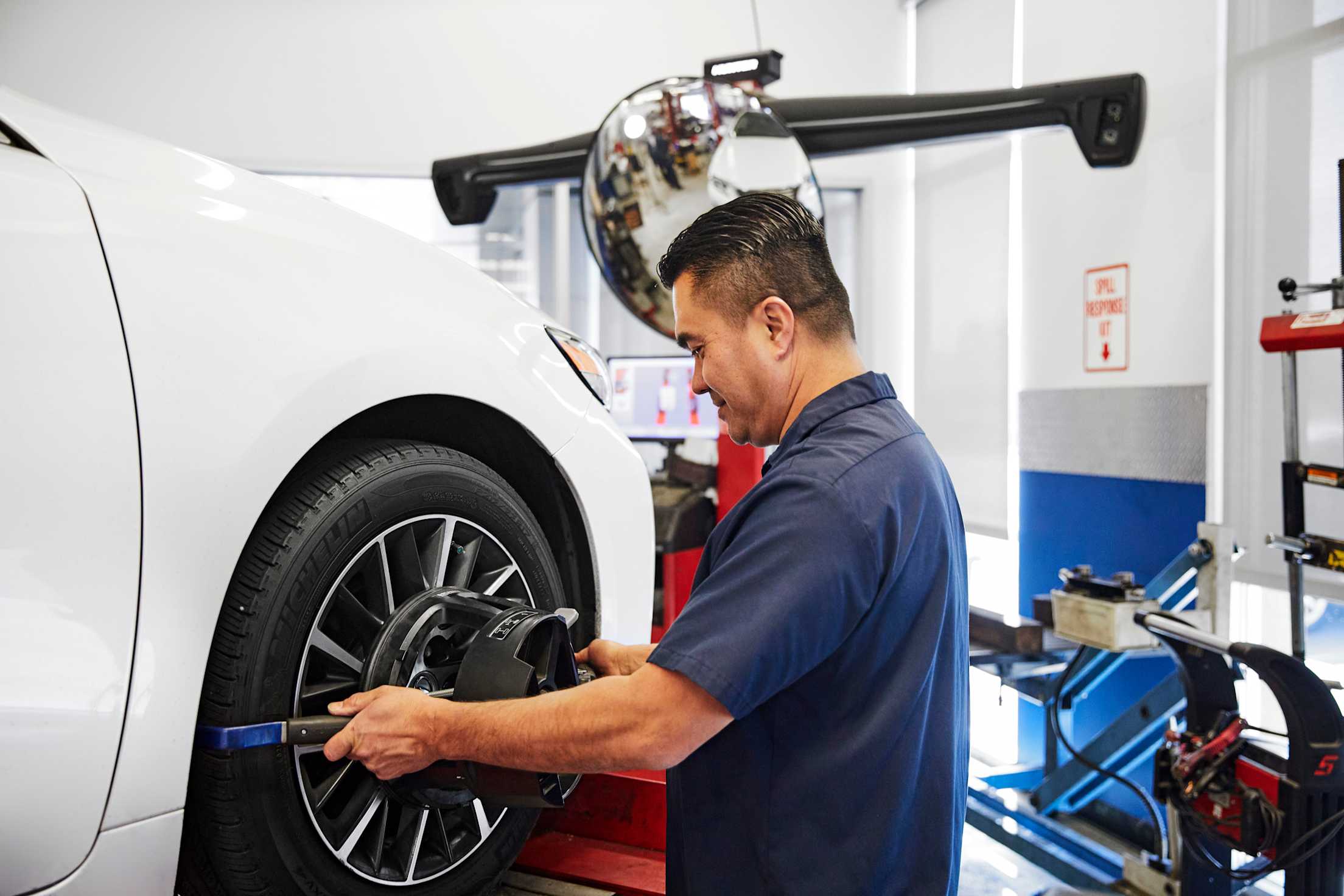 A mechanic performs a wheel alignment at AAA Car Care Plus in San Jose.  