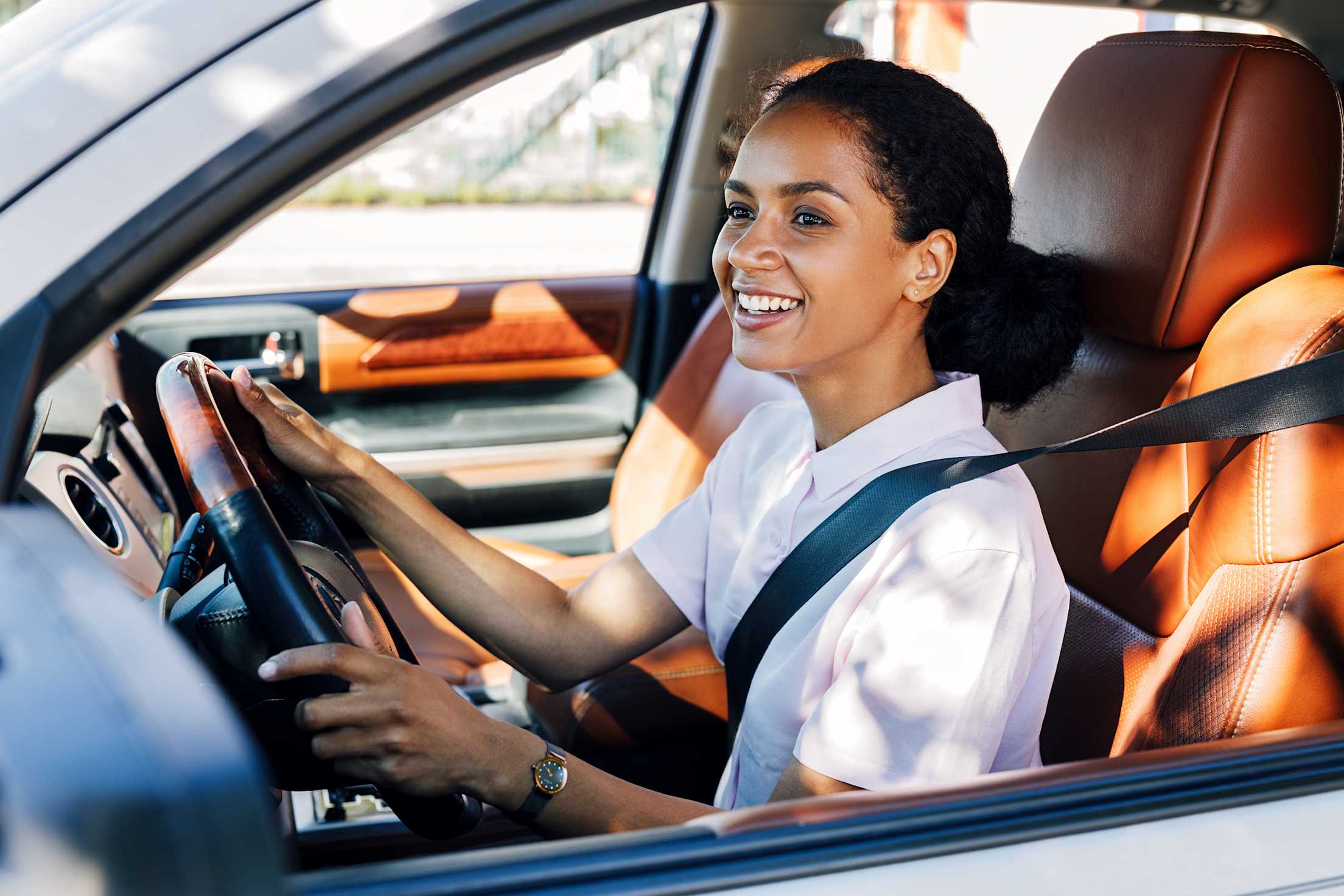 A woman drives on a sunny day.