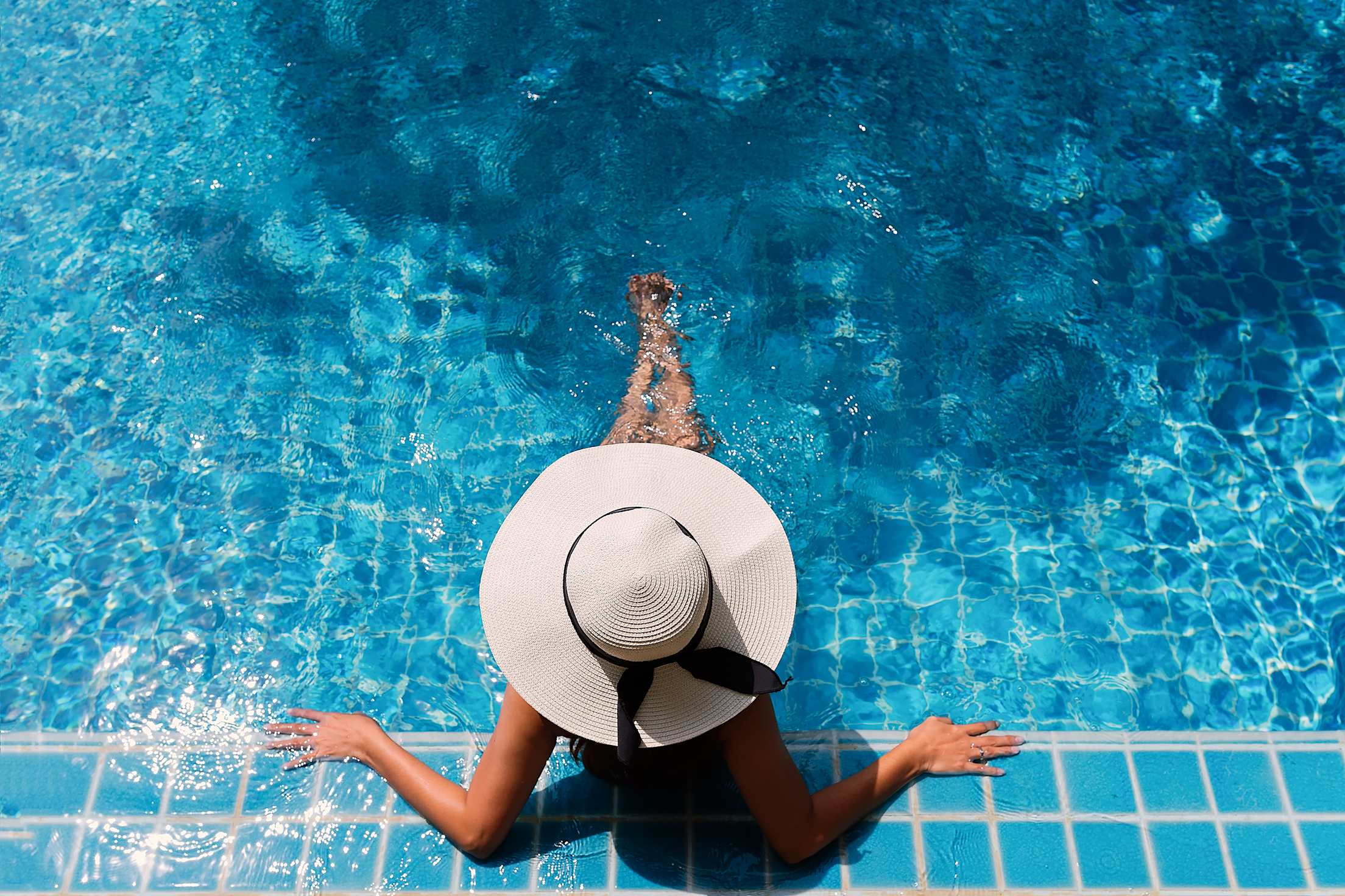 A woman relaxes in a tile pool.