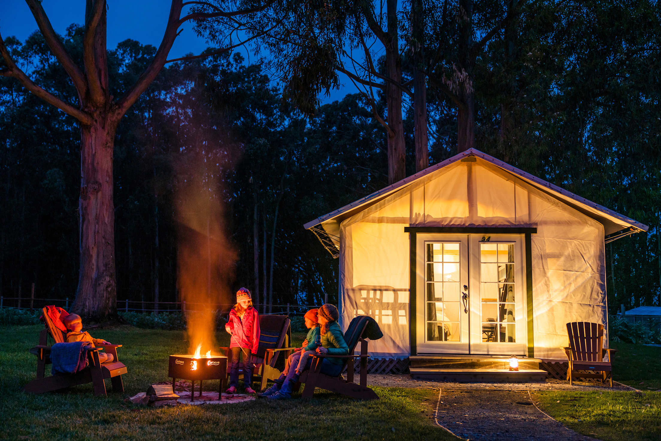 A family around the firepit at Costanoa's tent cabins.