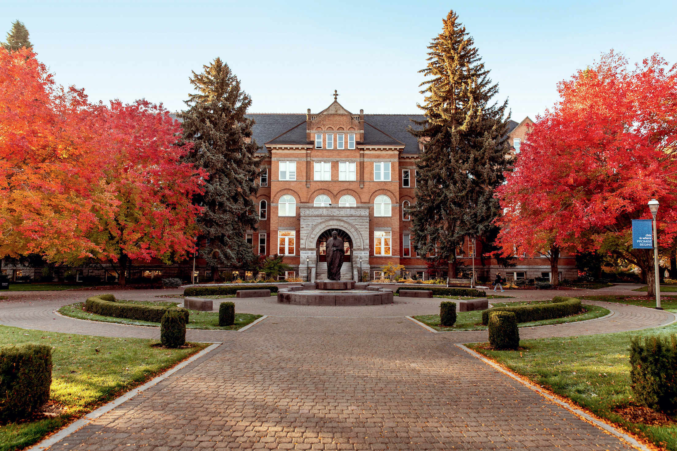 College Hall at Gonzaga University in Spokane, Washington surrounded by trees with red leaves.