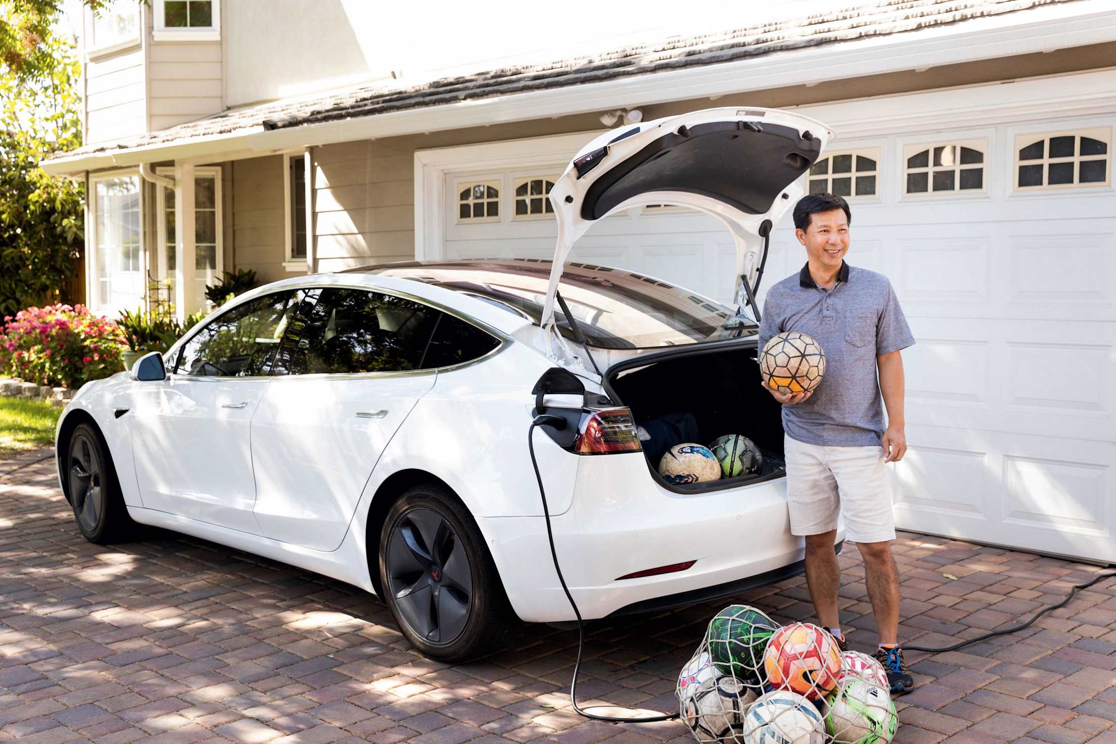 Khoi Tran stands next to his Tesla Model 3.