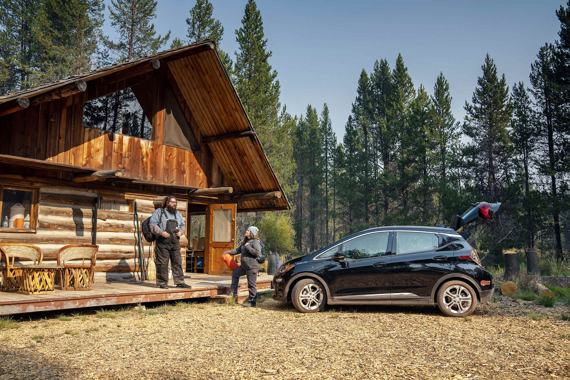 Erich Wise and Leah Laird unload their Chevy Bolt outside their cabin.