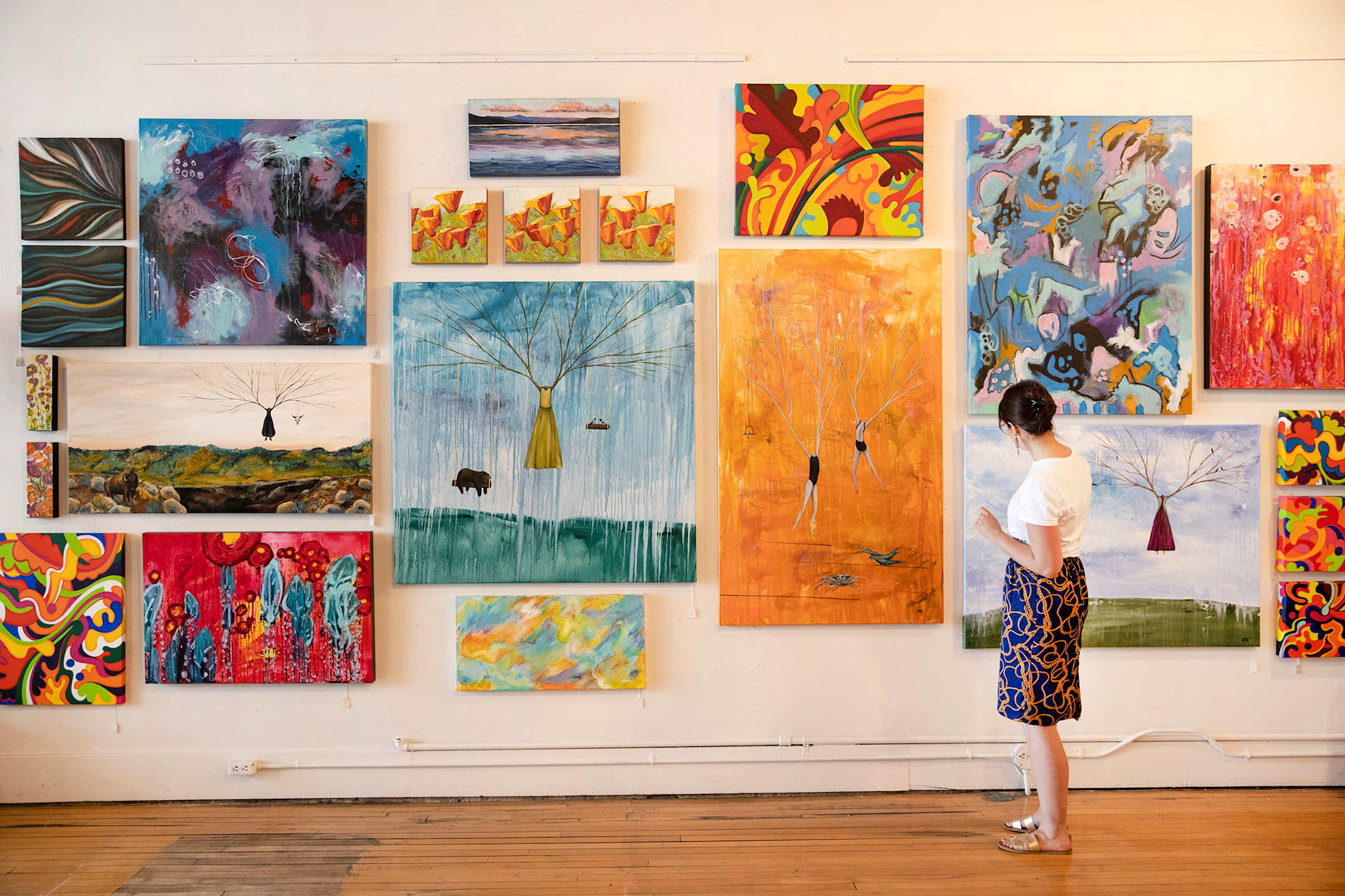 A woman stands in front of a gallery wall at Toucan.
