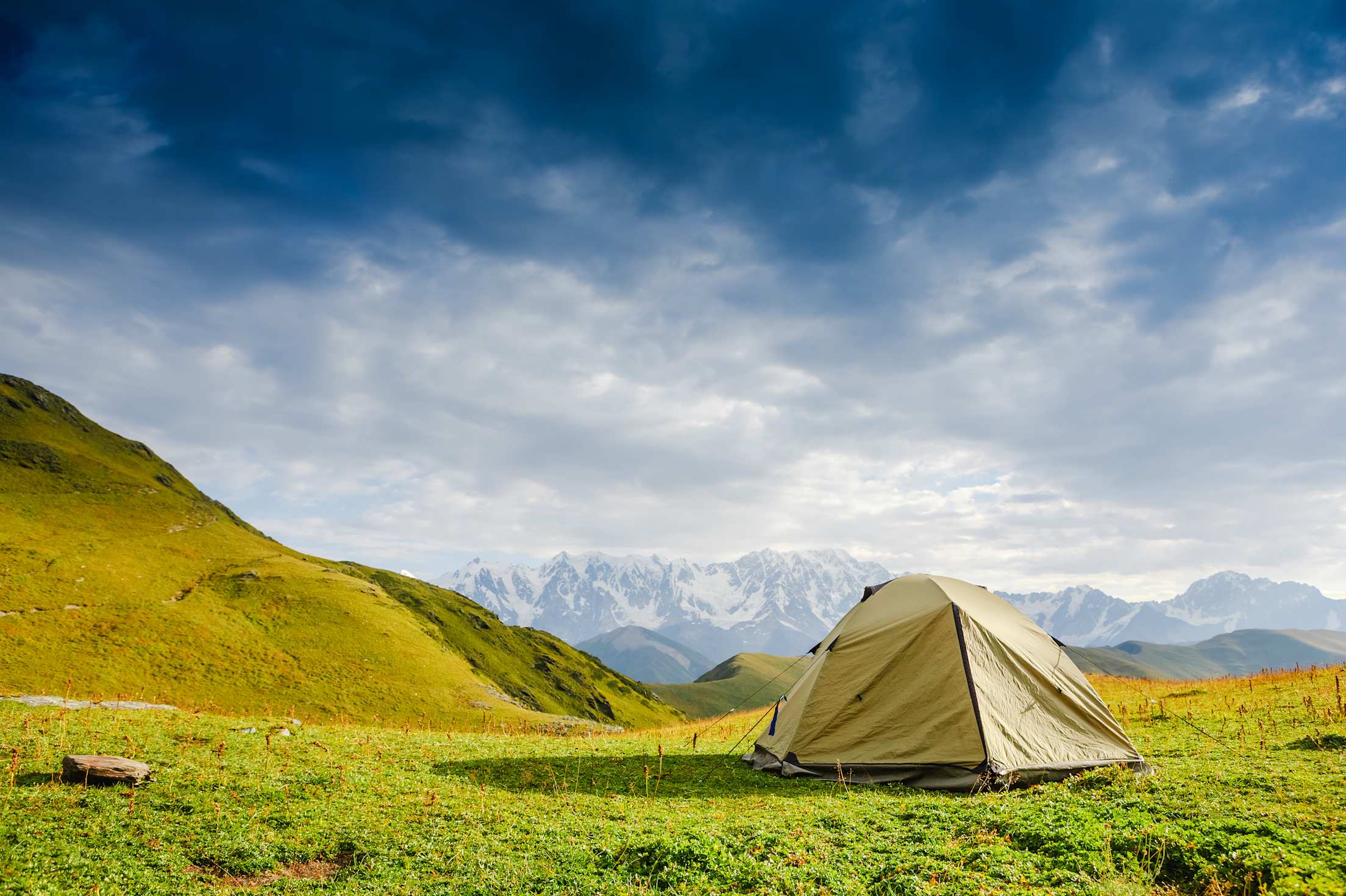 picture of a pitched tent on the grass overlooking beautiful view