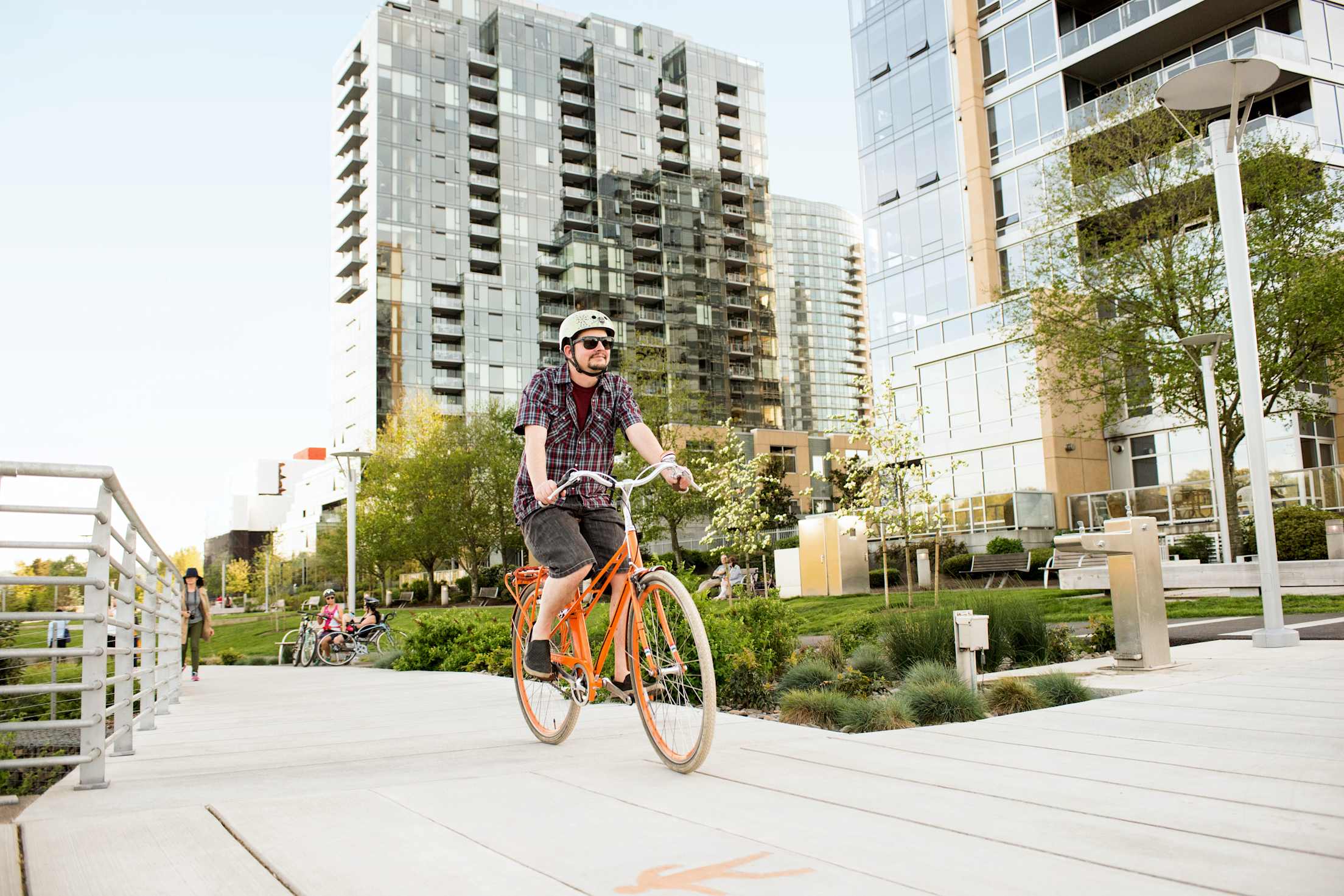 A person rides an orange bike on the South Waterfront Greenway in Portland, Oregon.