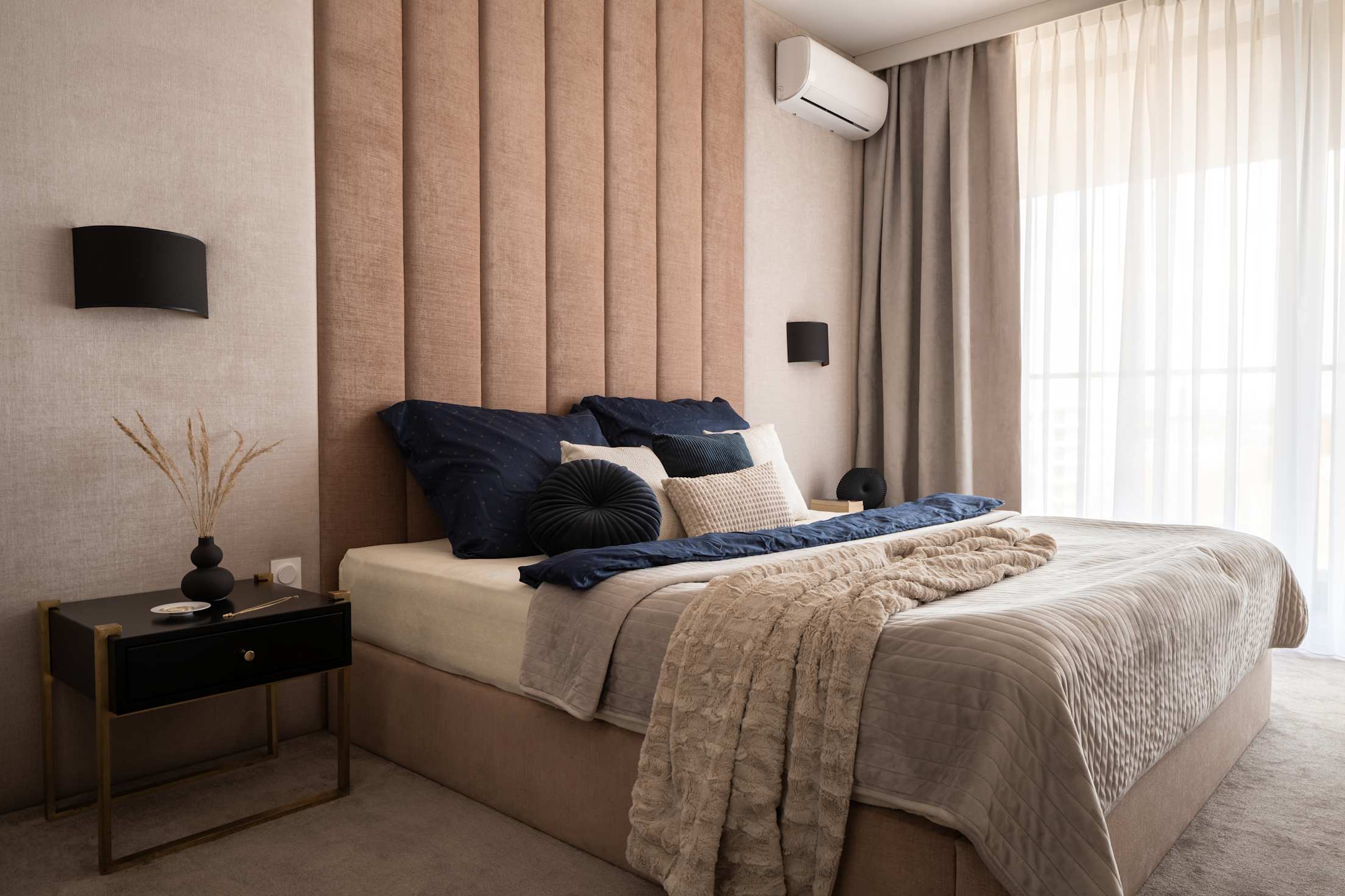 A modern bedroom with a mini split heat pump unit in the corner.