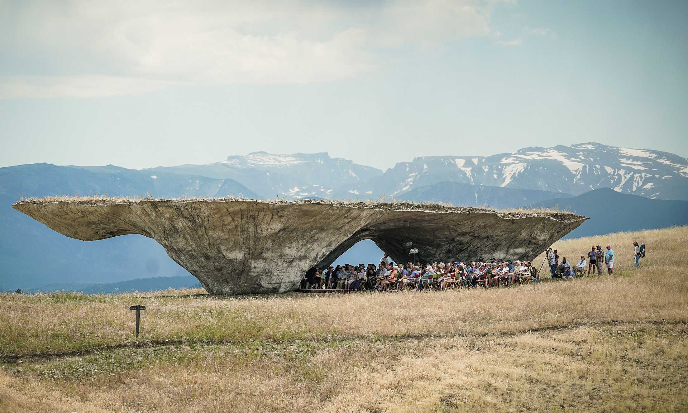 The Domo, a large-scale rock sculpture, features a flat surface on top and a carved area for audience seating below.