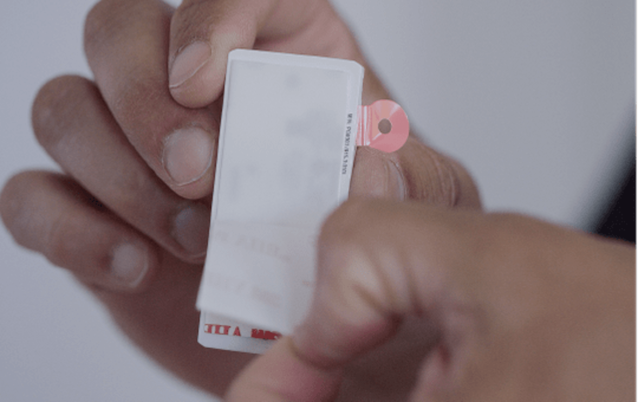 Hands peeling a sticky tape off entry sensor