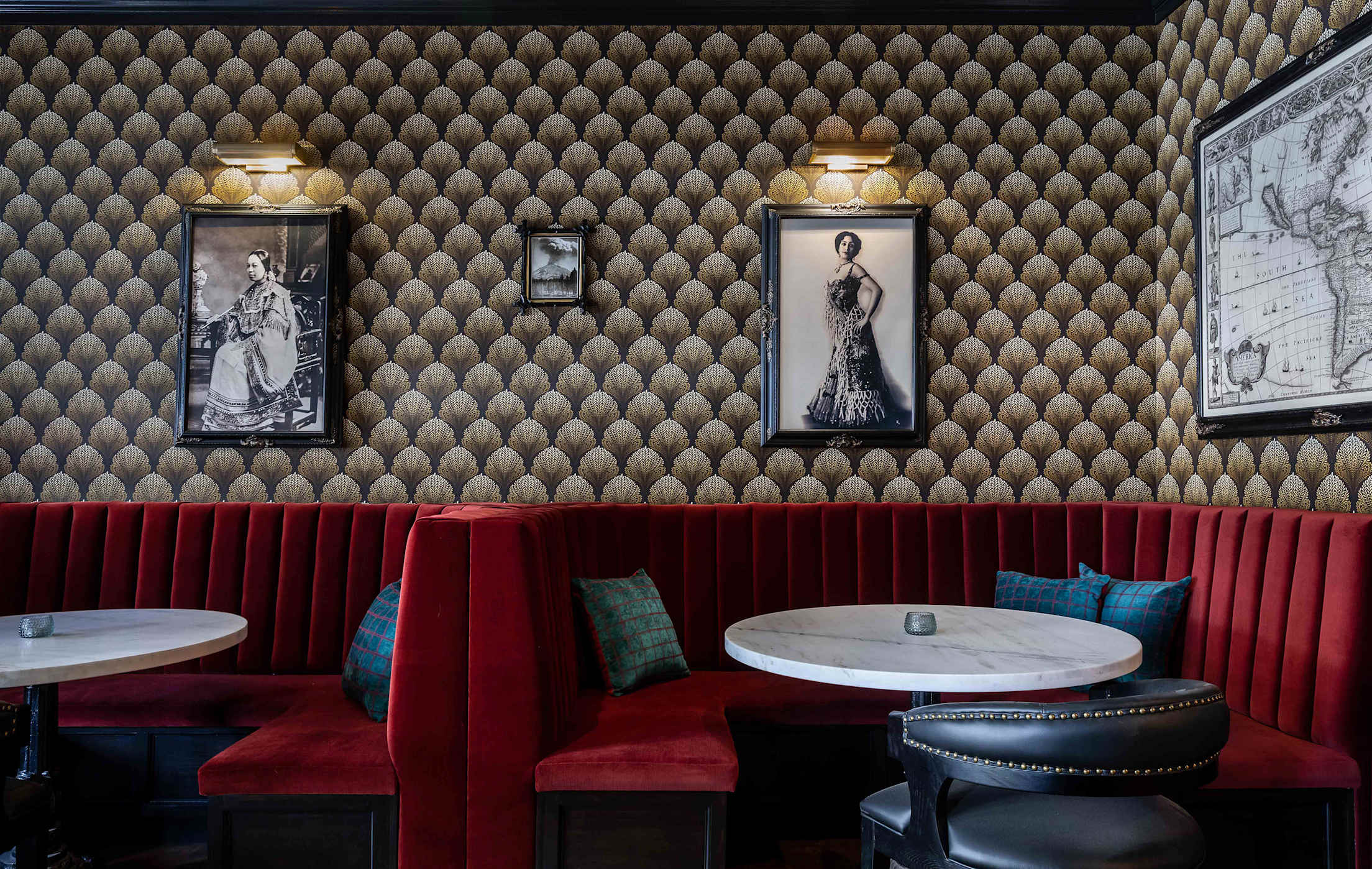 Red booths surrounded by historic images and wallpaper in the bar at National Exchange Hotel in Nevada City, California.