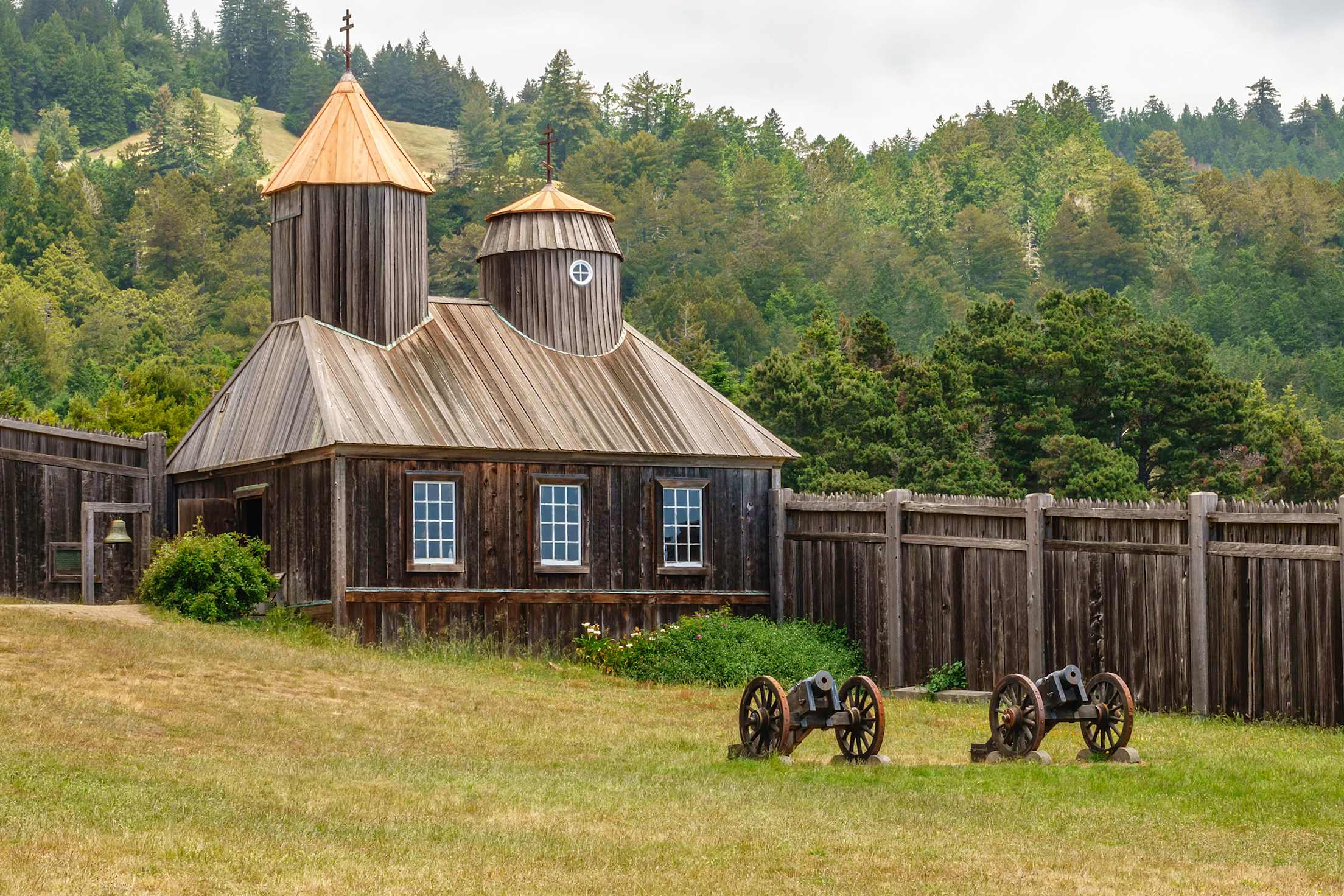 Two antique cannons in front of the restored Russian Orthodox chapel (originally built around 1825) at Fort Ross State Historic Park in Jenner, California.