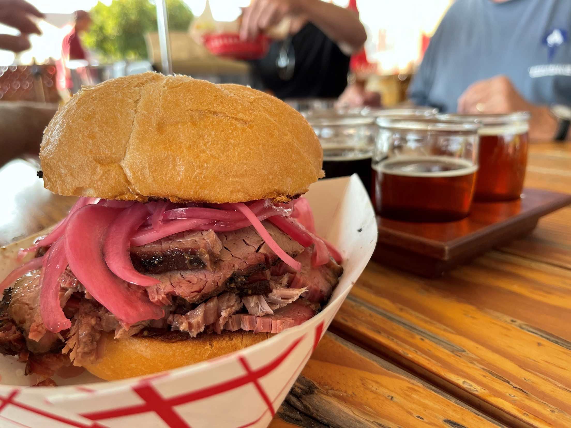a brisket sandwich with a tasting flight of beer behind it at Mad River Brewing Company.