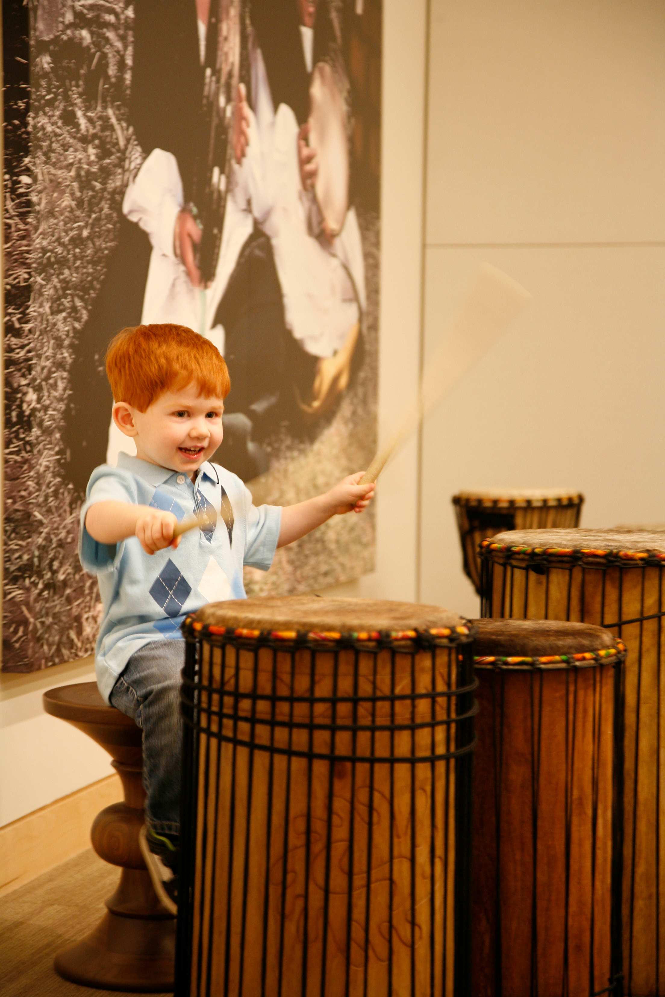 a kid plays wooden drums at Musical Instrument Museum in Phoenix, Arizona.